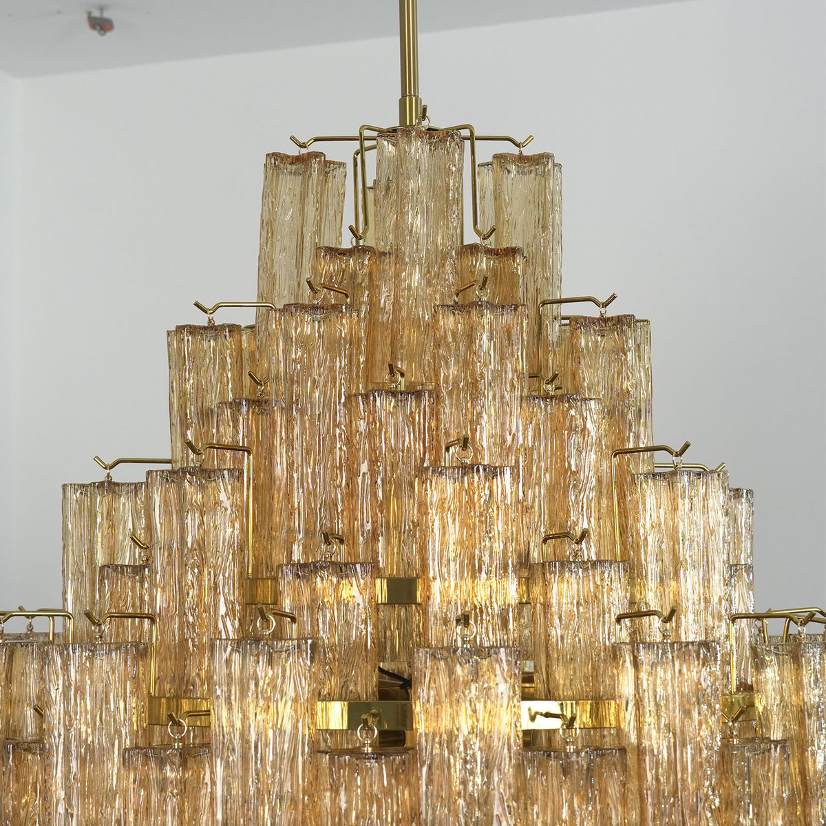 Addis Diamond Chandelier with amber glass, side view with tropical plant in background