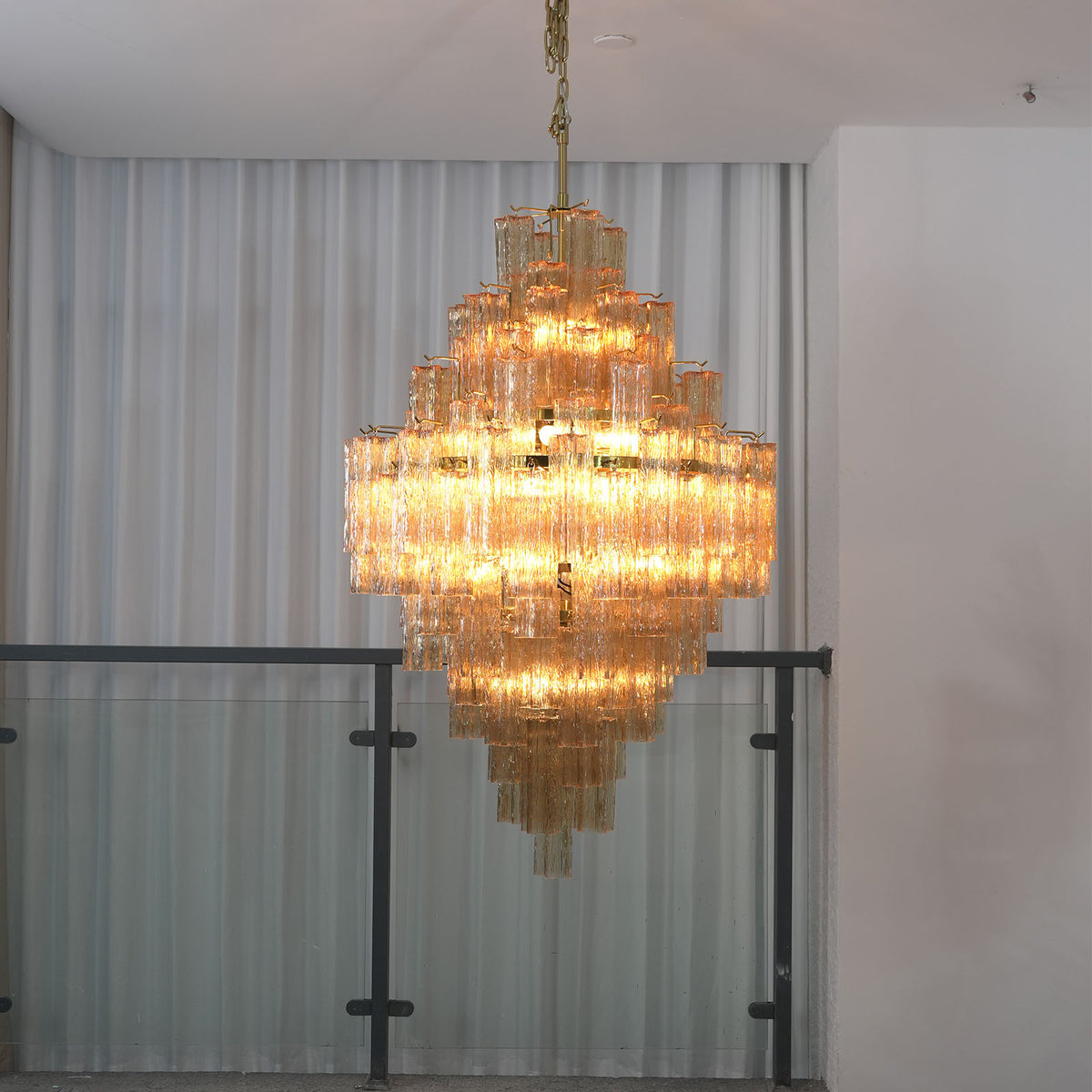 Addis Diamond Chandelier with glowing amber glass, warm light reflection on the glass tubes
