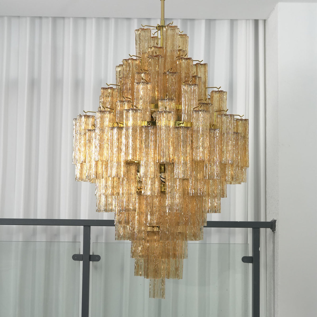 Addis Diamond Chandelier with amber glass, side view with sheer curtains in background