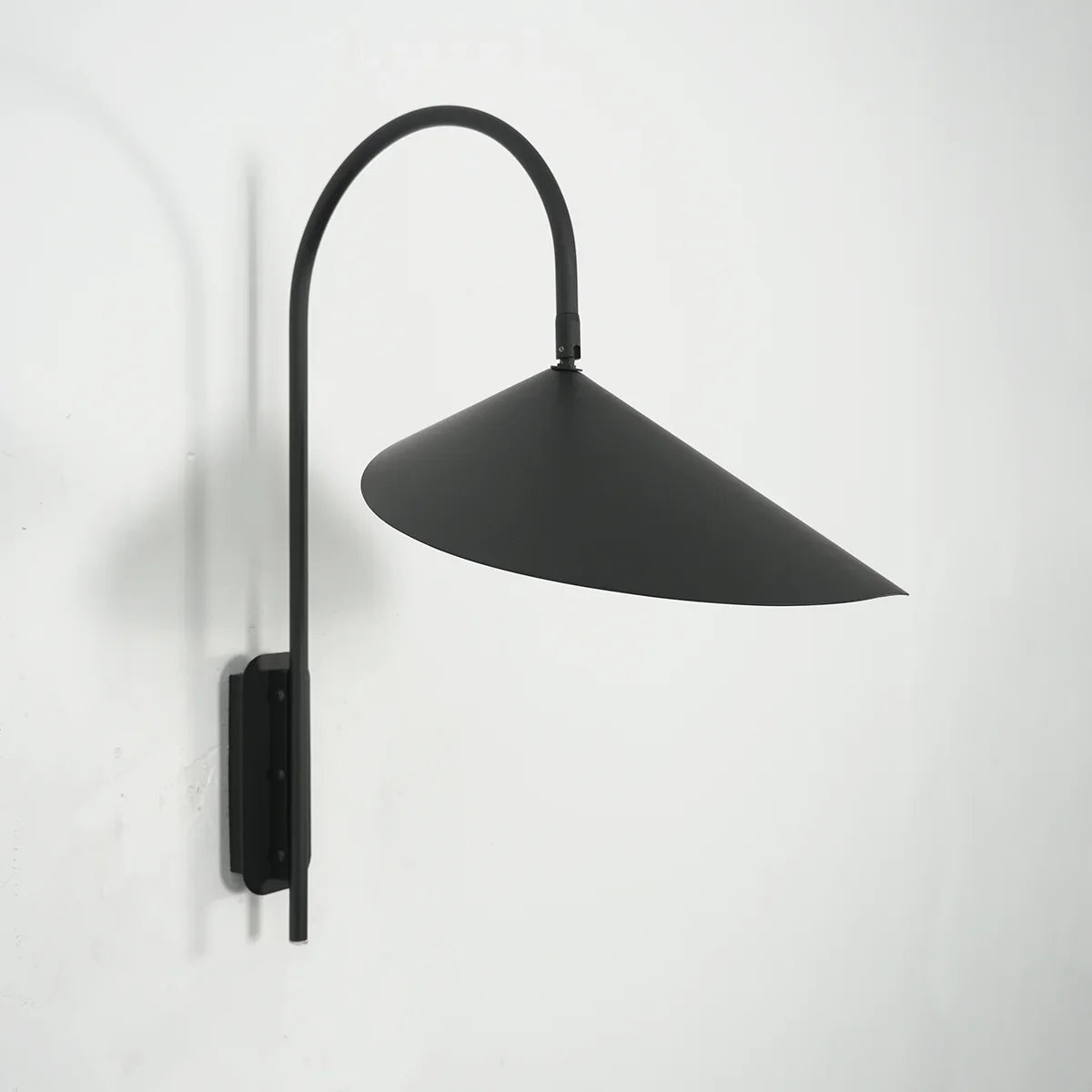 Arum Swivel Wall Lamp in brushed brass finish mounted on a plain white wall