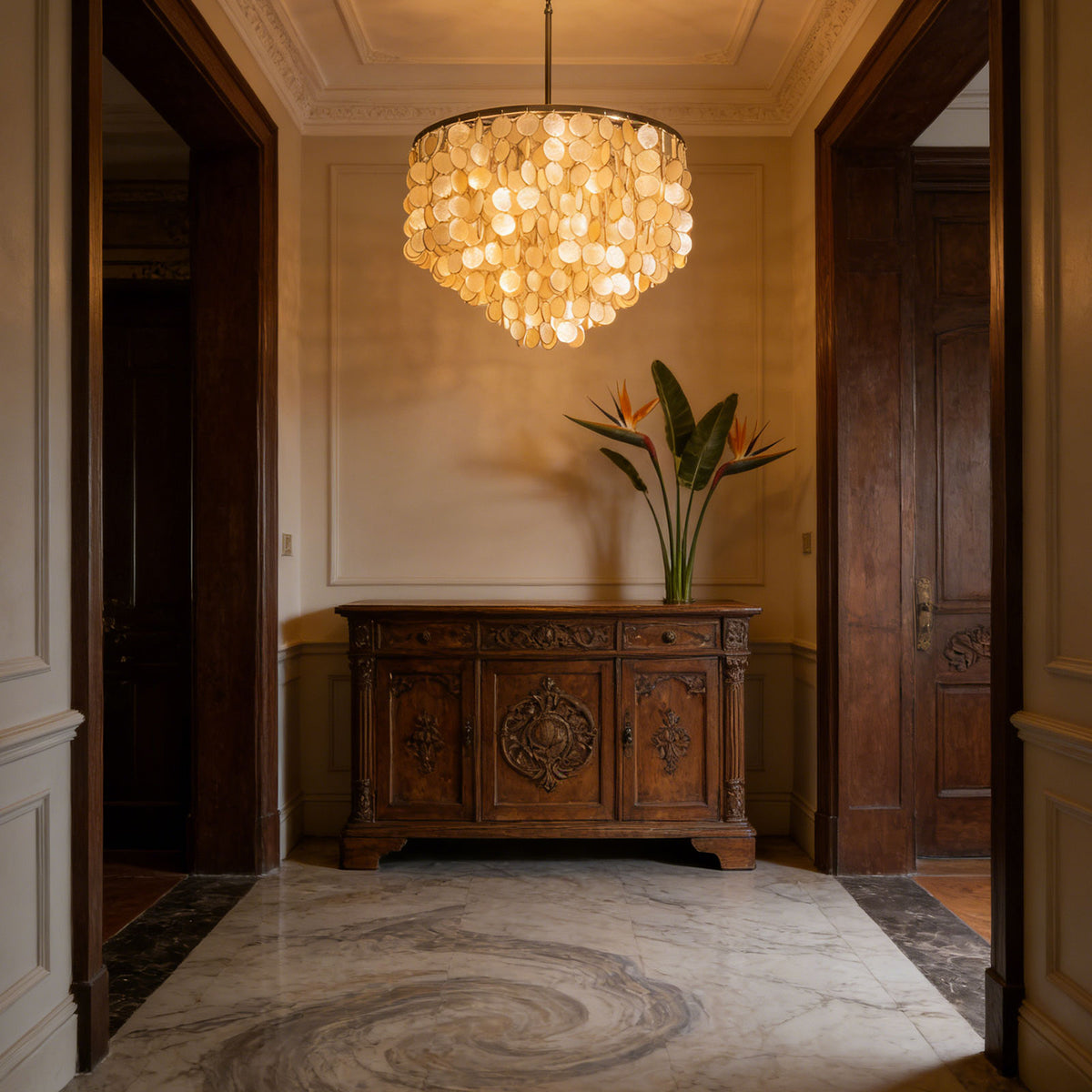 Capiz shell round chandelier in a warm-toned entryway with a carved wooden console.