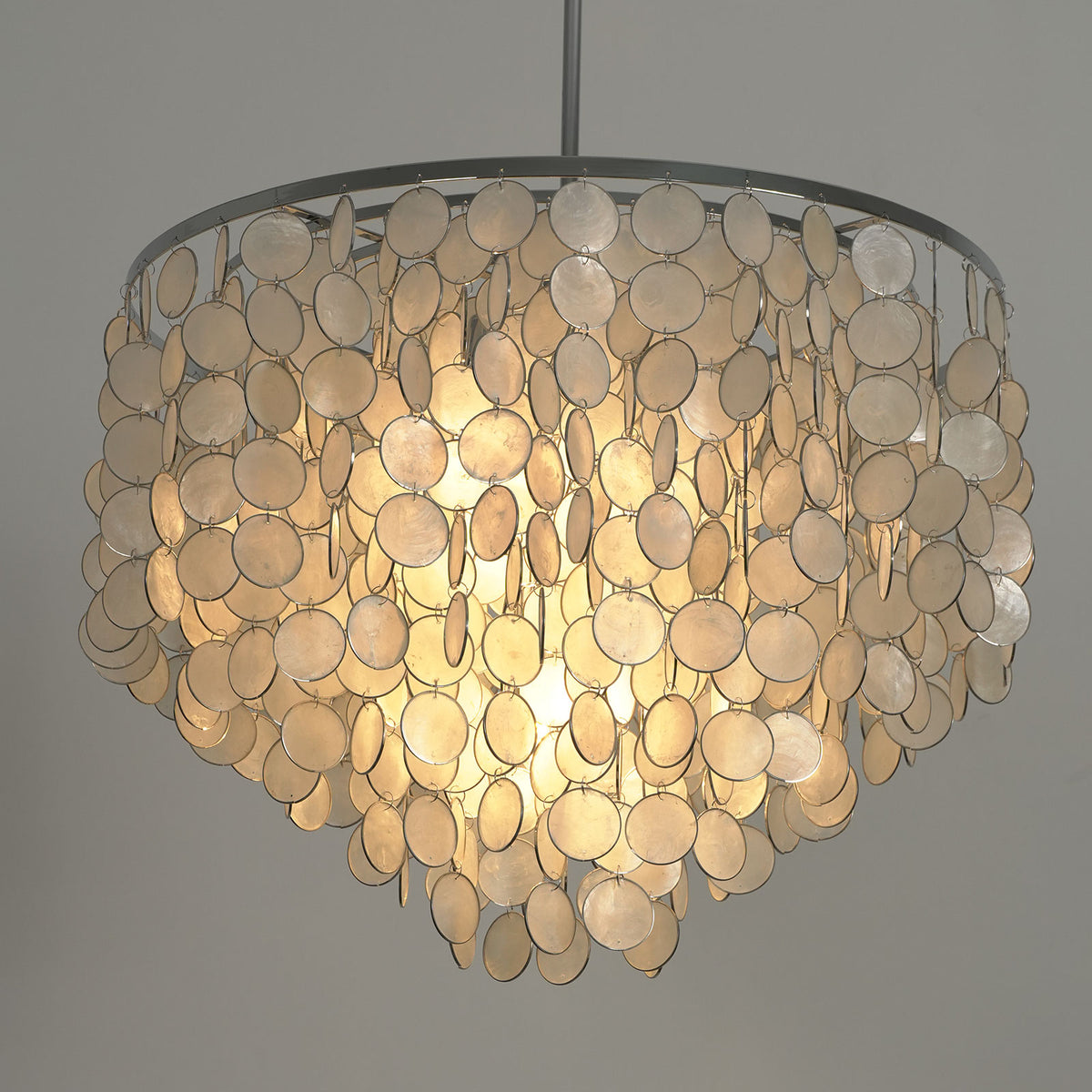 Close-up of the layered arrangement of capiz shell discs on the round chandelier.