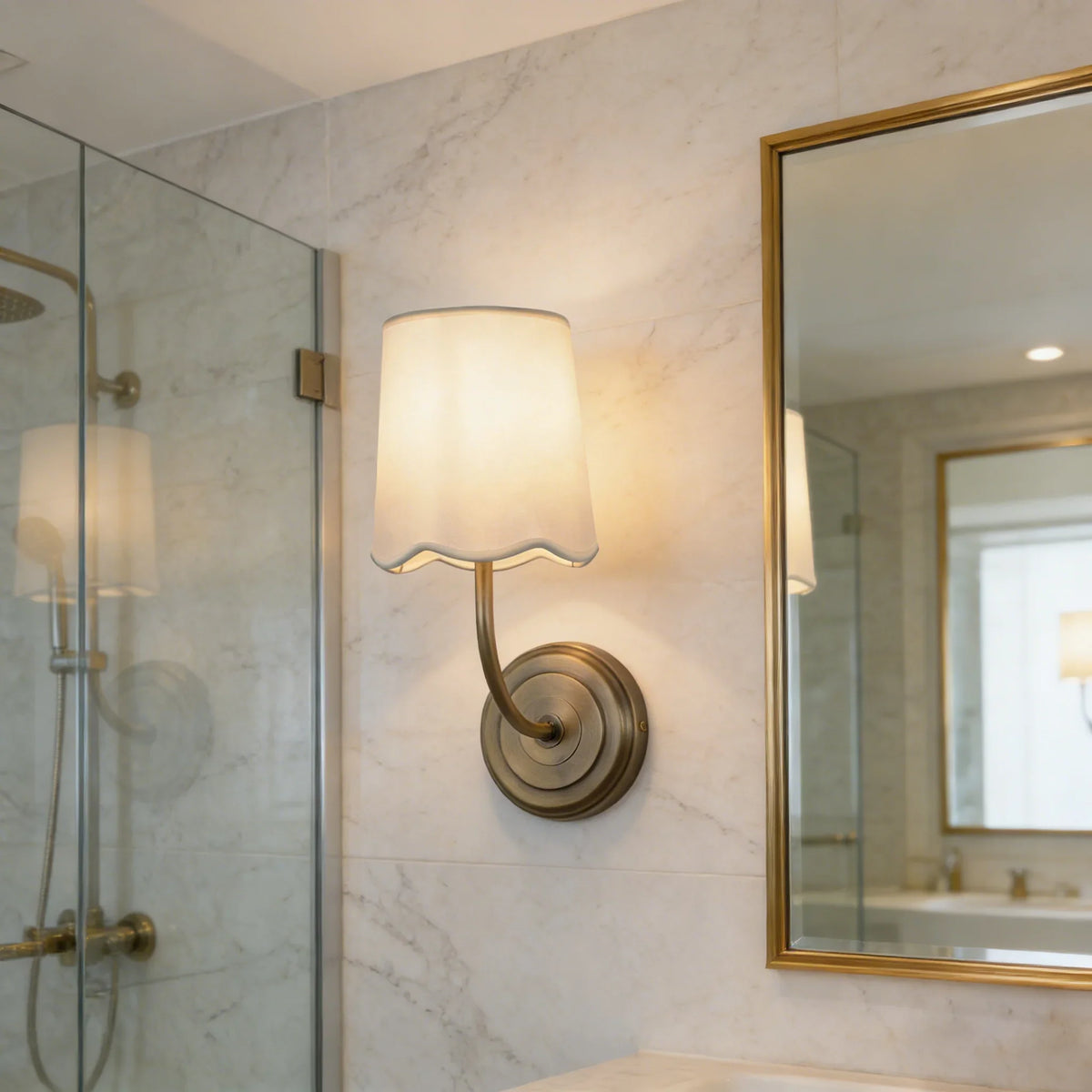 Lit Curved Arm Fabric Wall Sconce in a modern bathroom with marble walls