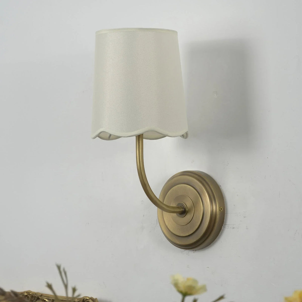 Unlit Curved Arm Fabric Wall Sconce in a bright corner with soft background