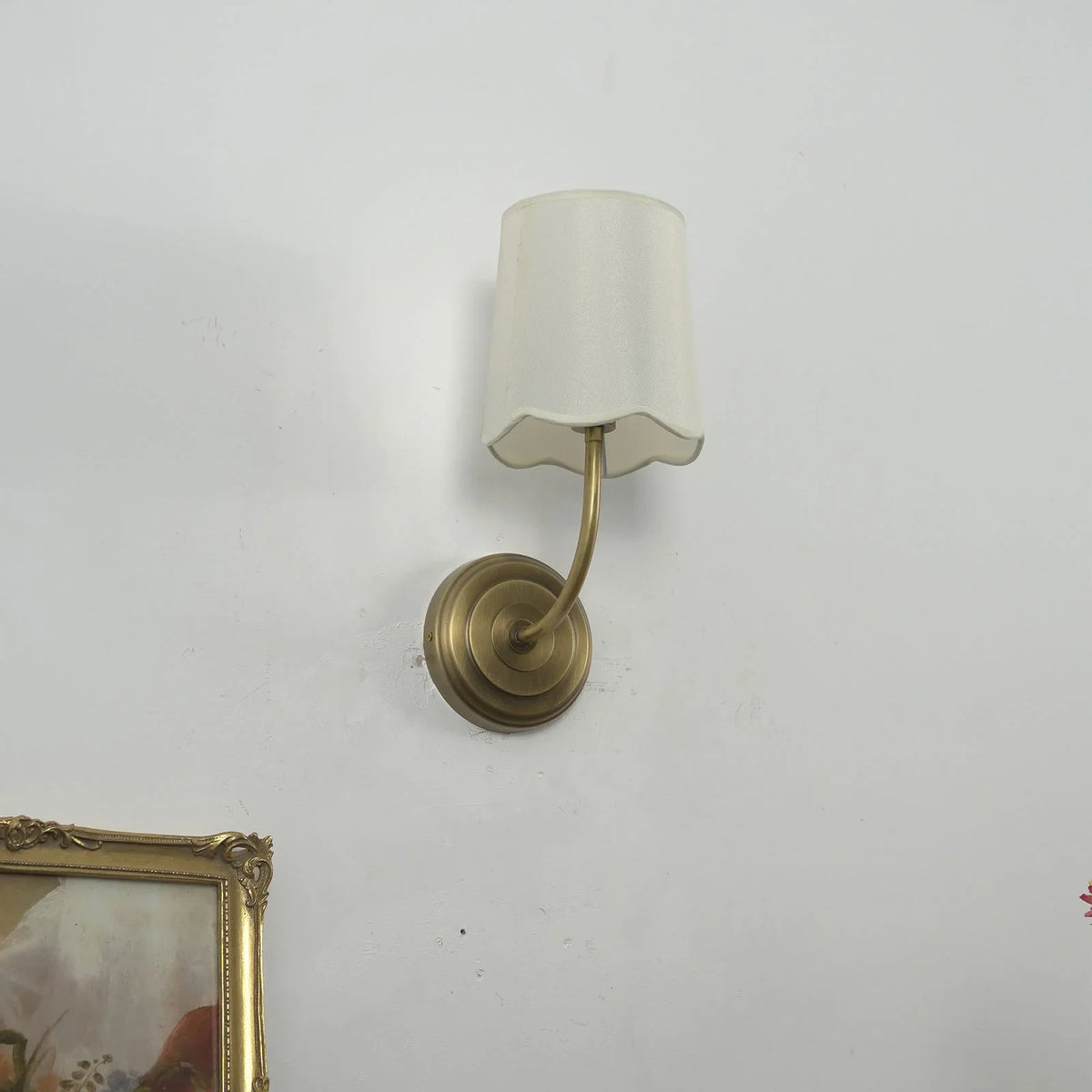 Close-up of the antique brass wall mount and curved arm base