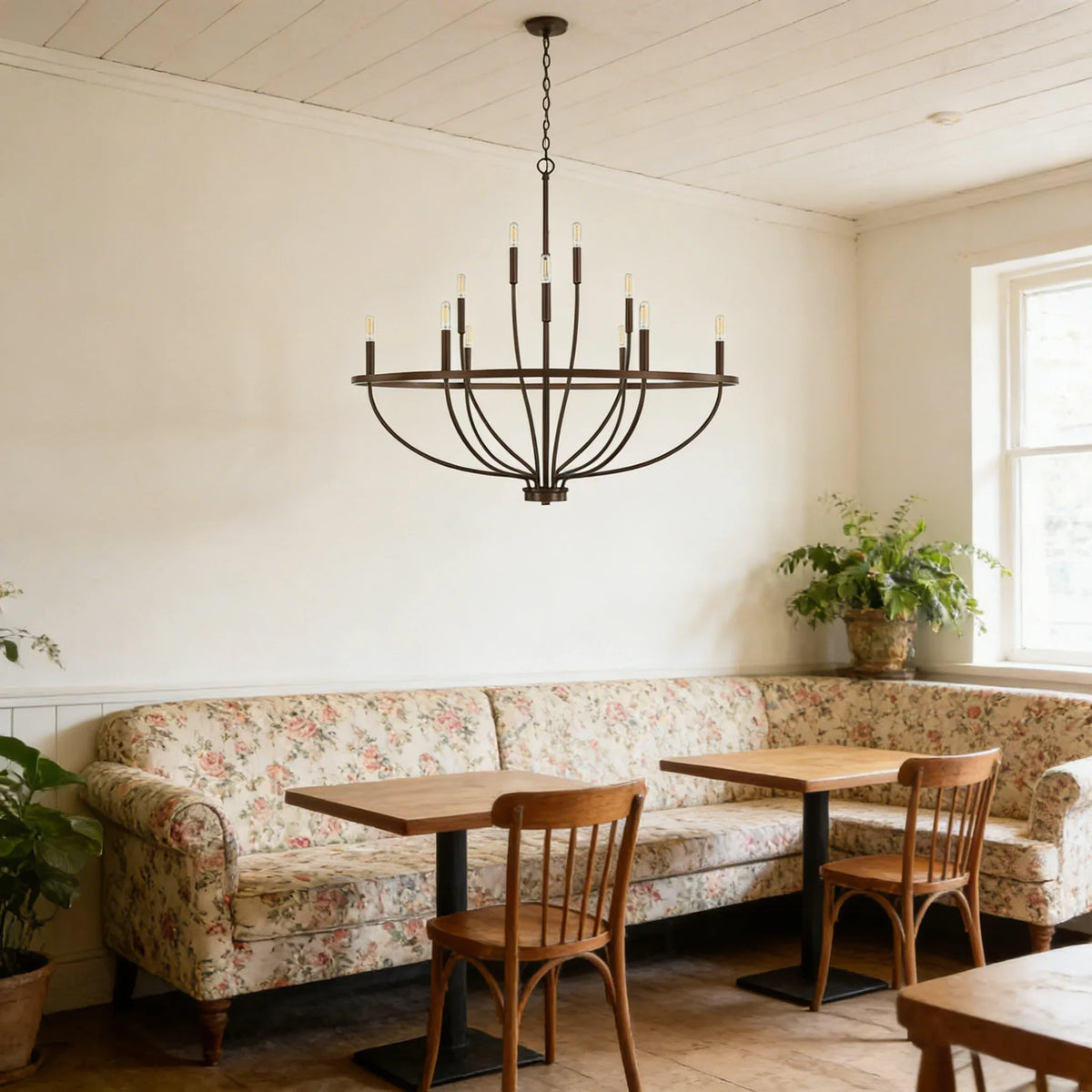 Greyson Bowl Chandelier hanging above a dining table with floral sofa and wooden chairs