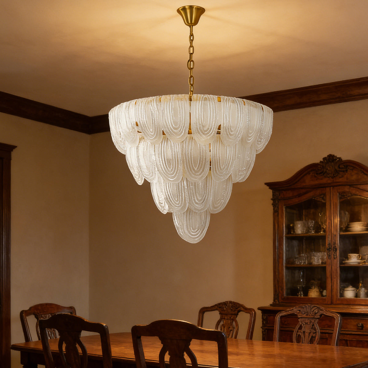 Layered glass petal chandelier in a formal dining room with dark wooden furniture and warm lighting.