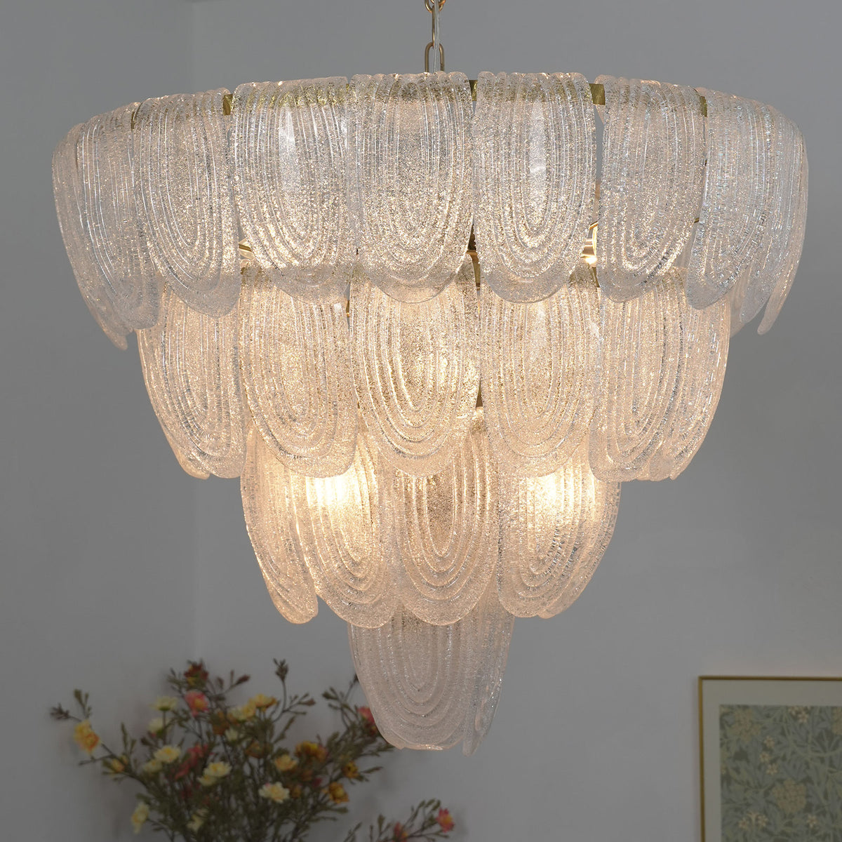 Close-up of the textured surface on the clear glass petals of the layered chandelier.