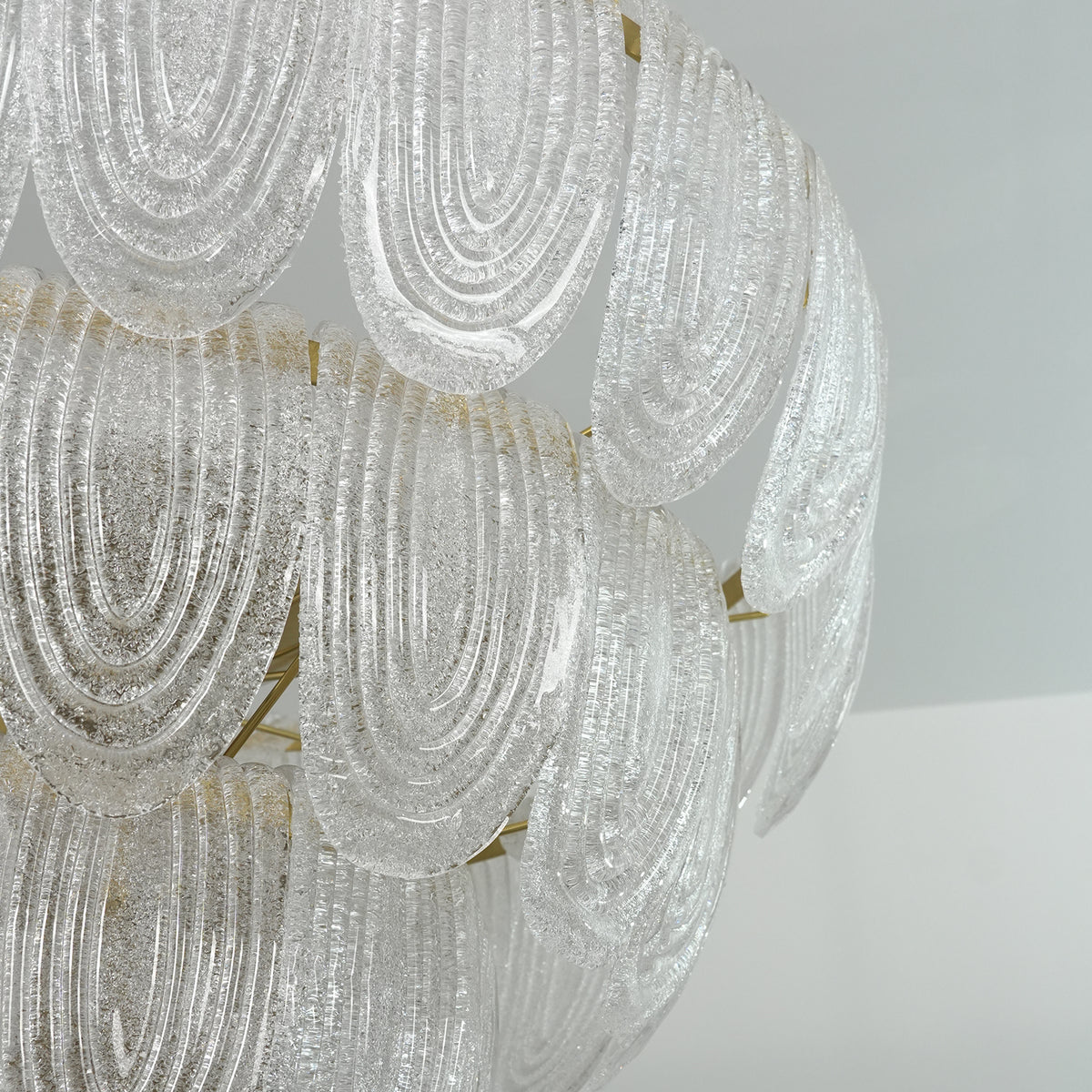 Close-up of the gold metal hardware and glass petal attachment points on the chandelier.