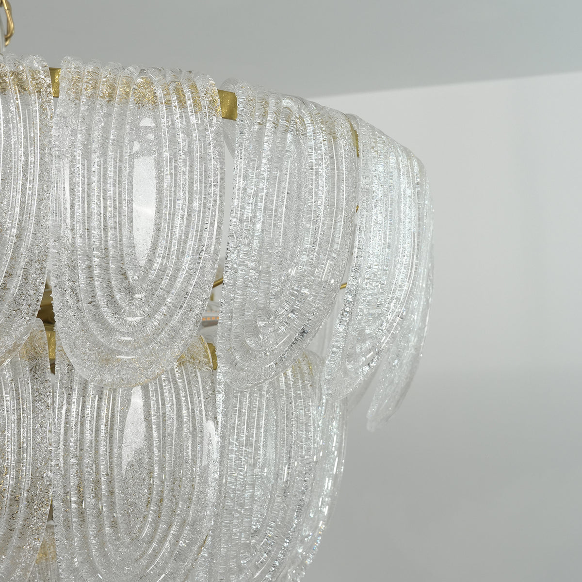 Close-up of the tiered glass petal layers on the modern chandelier, showing their drape and texture.