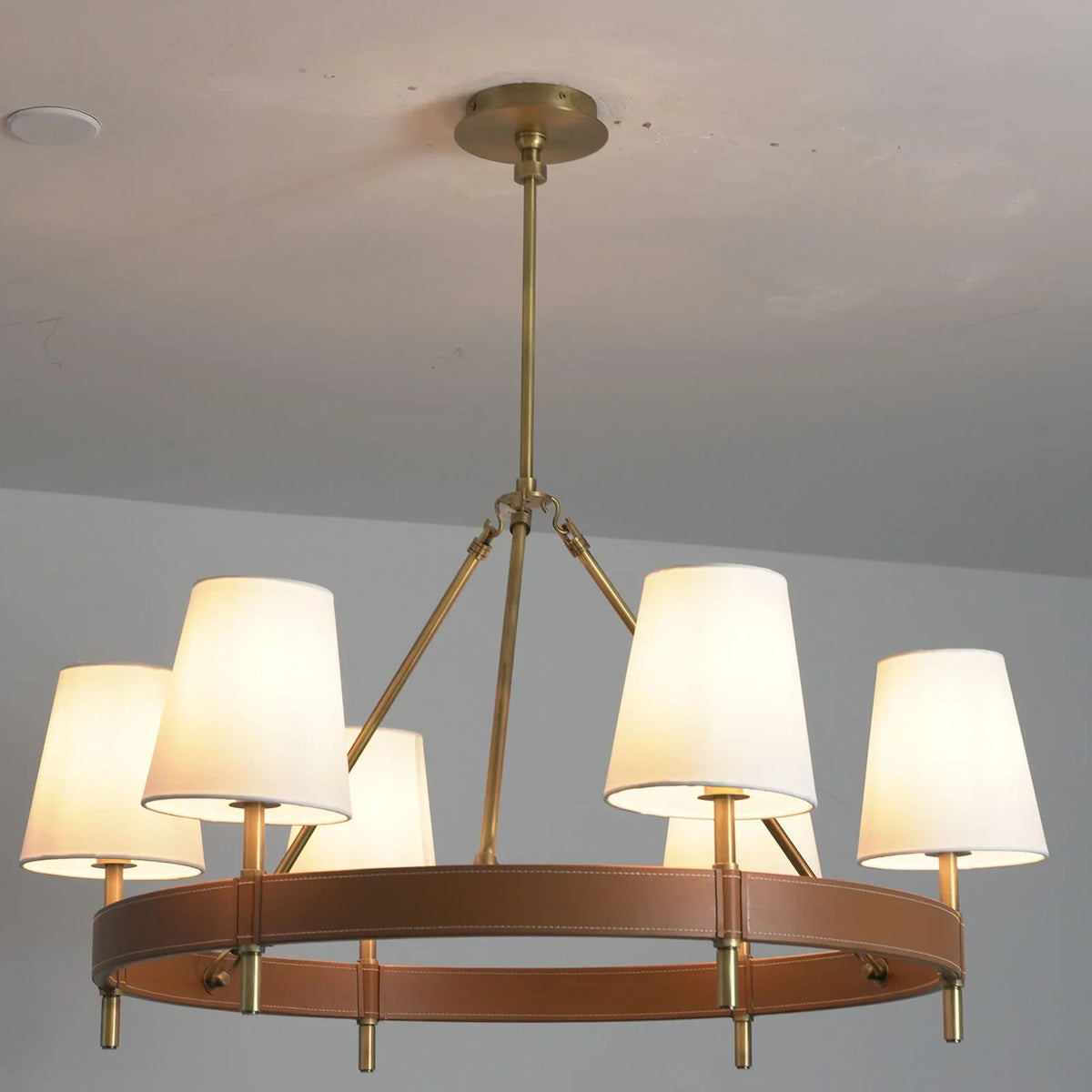 Angled view of the round Leather Halo Ring Chandelier with soft light