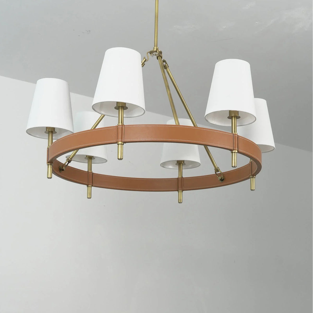 Angled view of the round Leather Halo Ring Chandelier showing the brass hardware