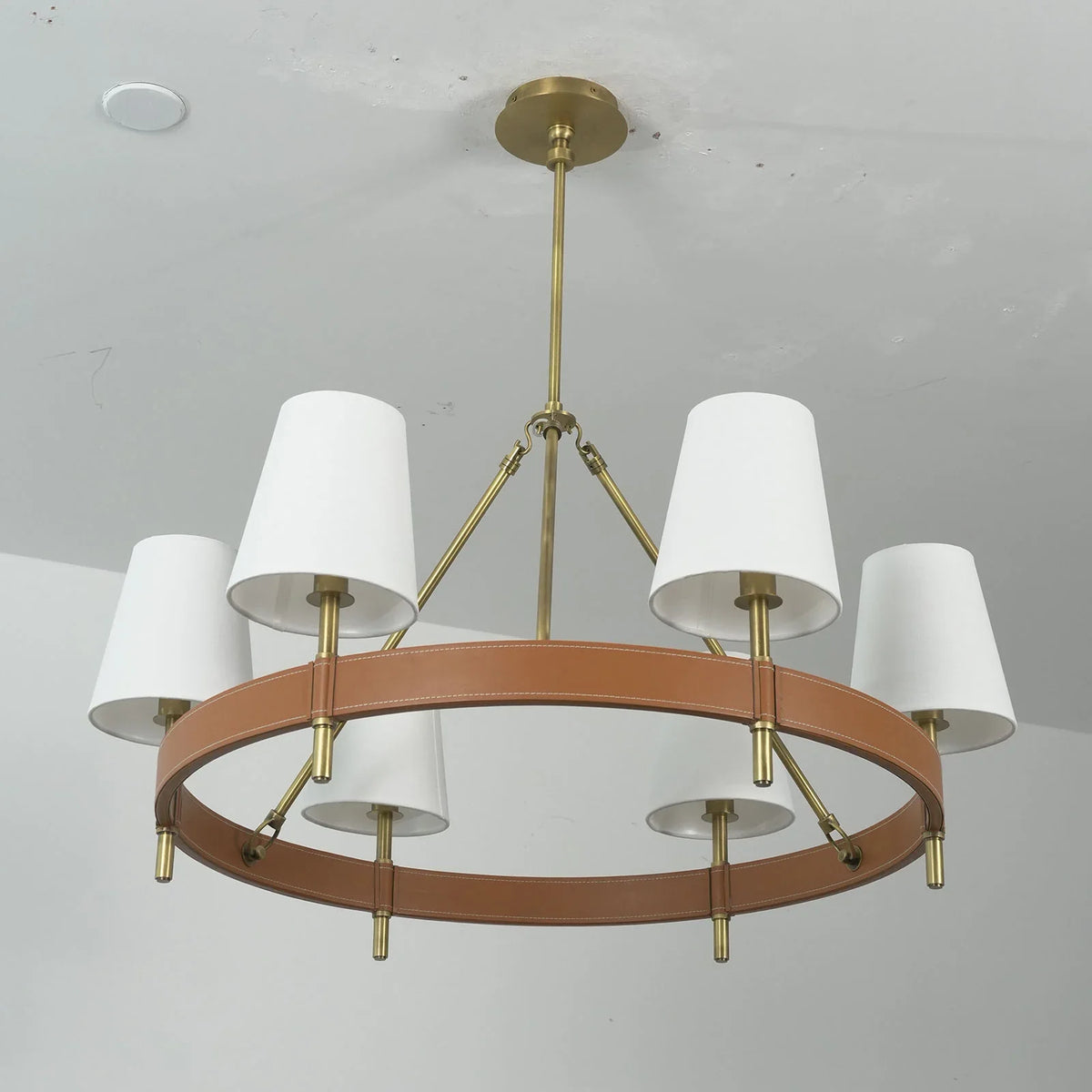 Angled view of the round Leather Halo Ring Chandelier with all fabric shades lit