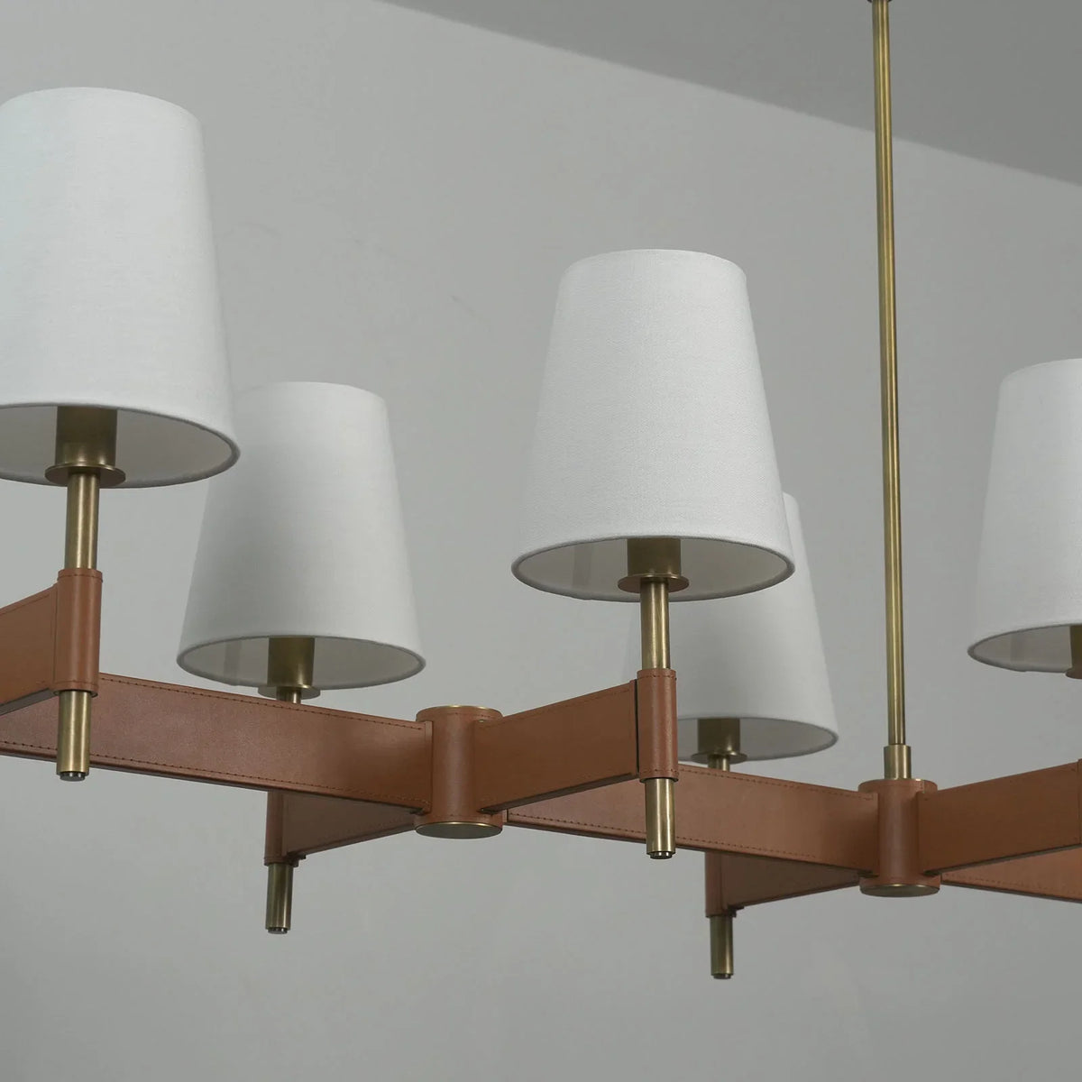 Close-up of the leather strap joint on the Leather Halo Chandelier showing stitching