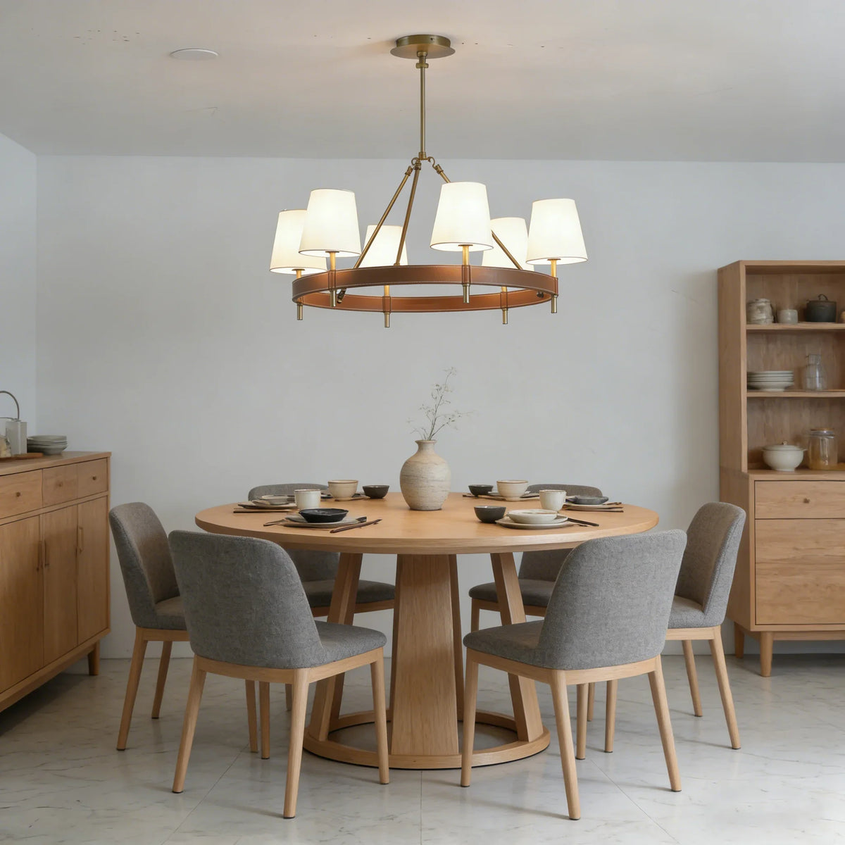 Leather Halo Ring Chandelier above a light wood dining table with grey upholstered chairs