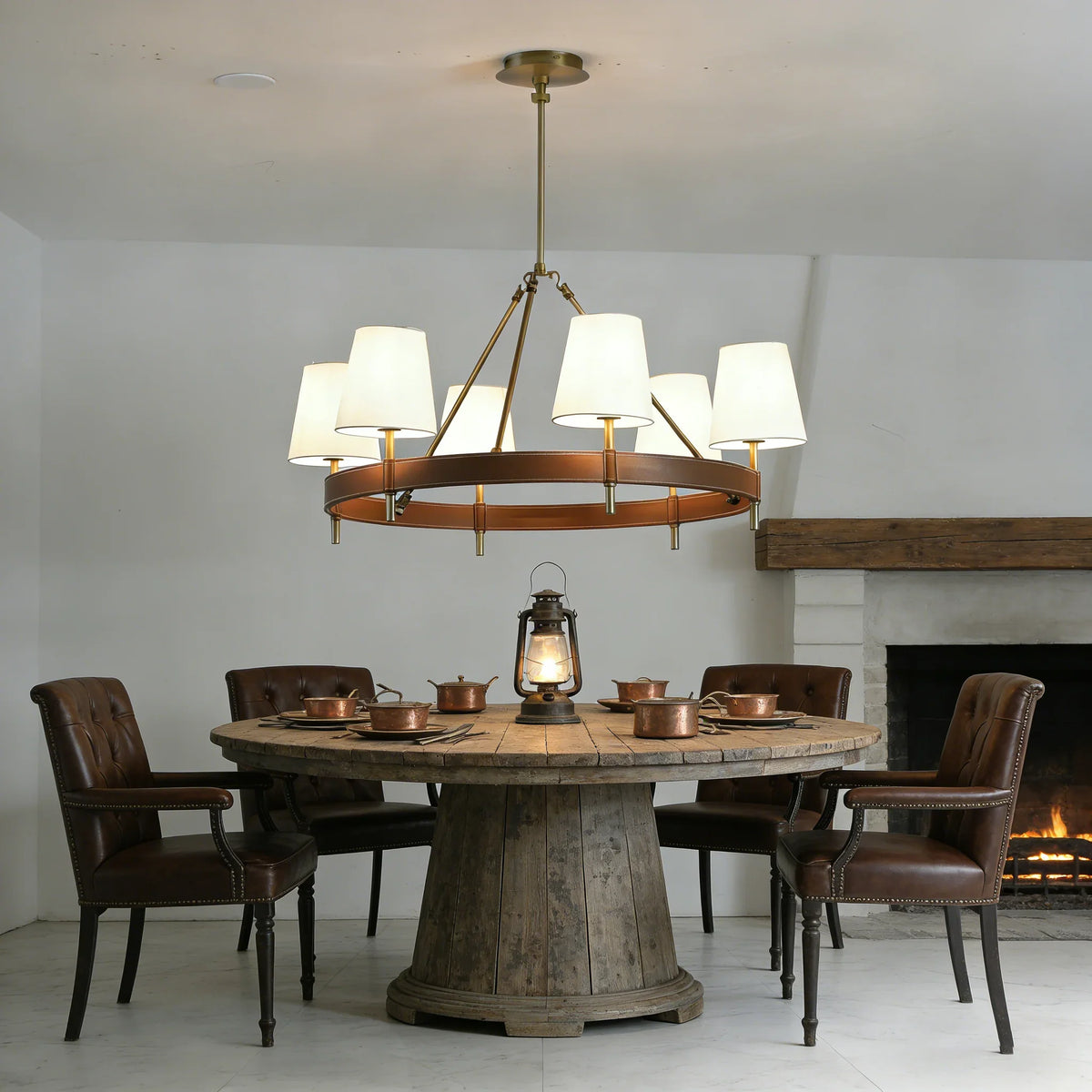 Leather Halo Ring Chandelier above a rustic dining table with dark wooden chairs