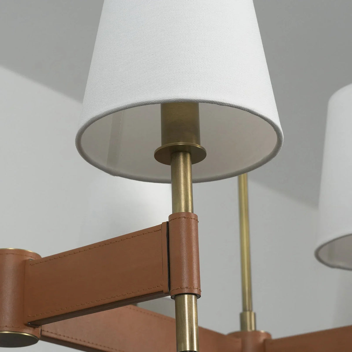 Close-up of the glowing white fabric shade on the Leather Halo Chandelier