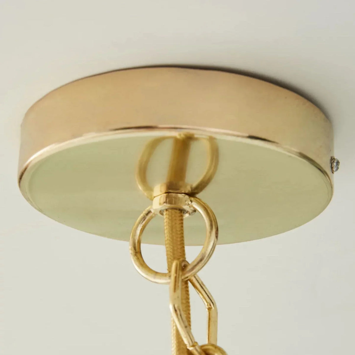 Close-up of the gold ceiling mount and hanging hardware of the Light Luxury Shell Chandelier