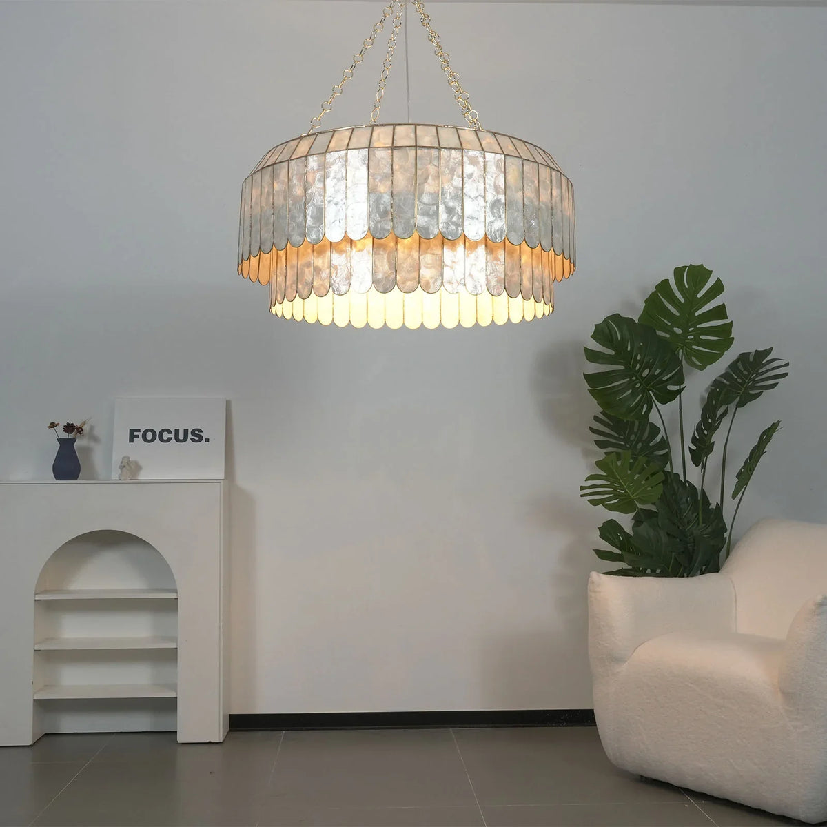 Light Luxury Shell Chandelier in a minimalist corner with a white armchair and plants