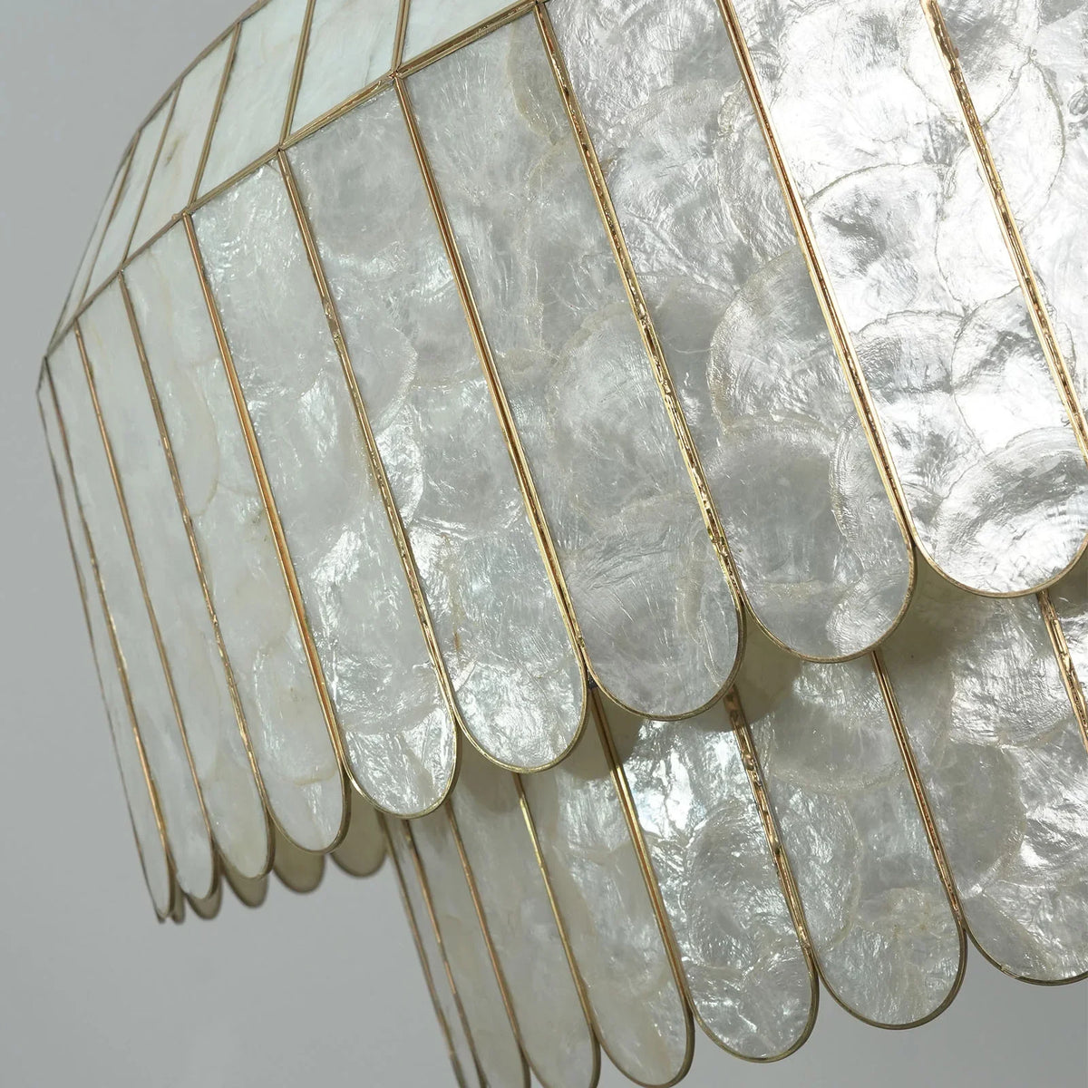 Close-up of soft pink capiz shells on the Light Luxury Shell Chandelier with gold trim