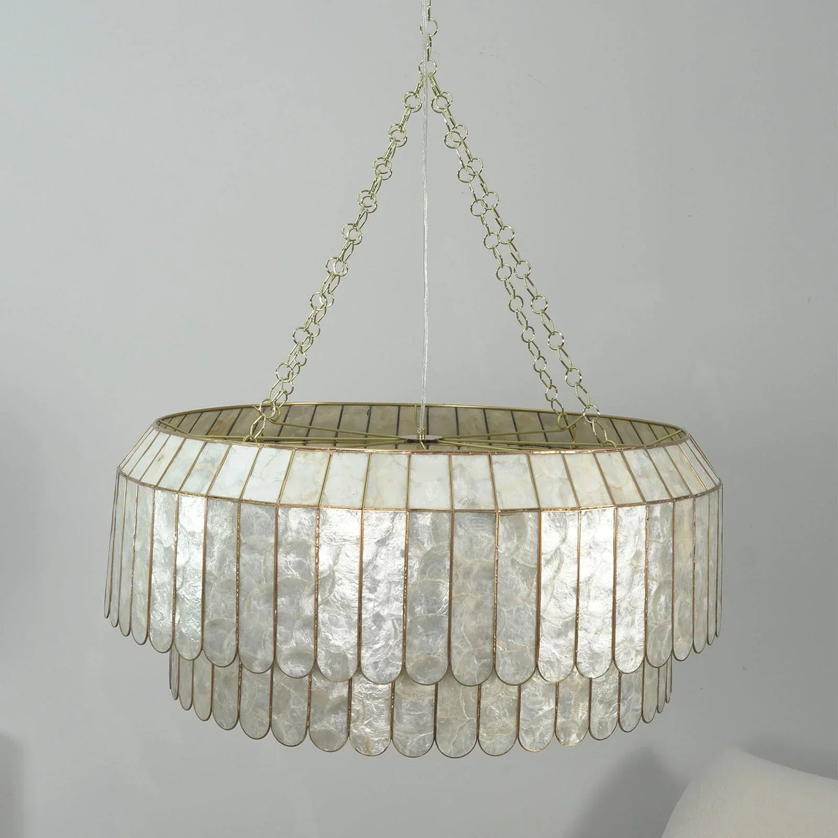 Side view close-up of the gold frame and layered capiz shells on the chandelier