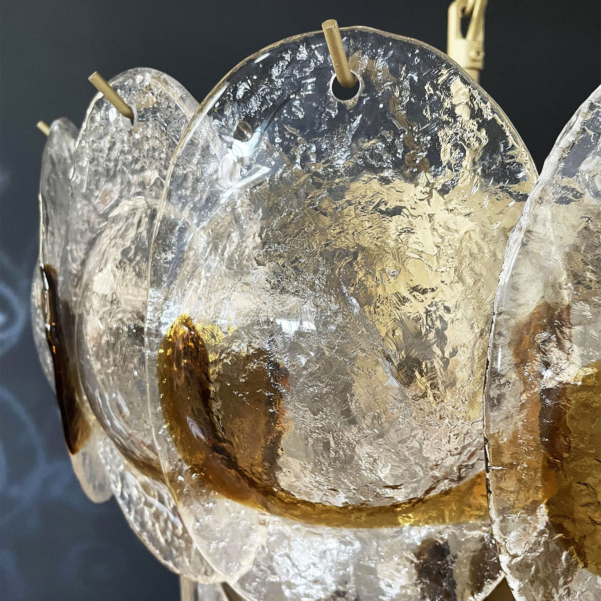 Close-up of the metal frame and glass disc attachment points on the Mazzega-style chandelier.