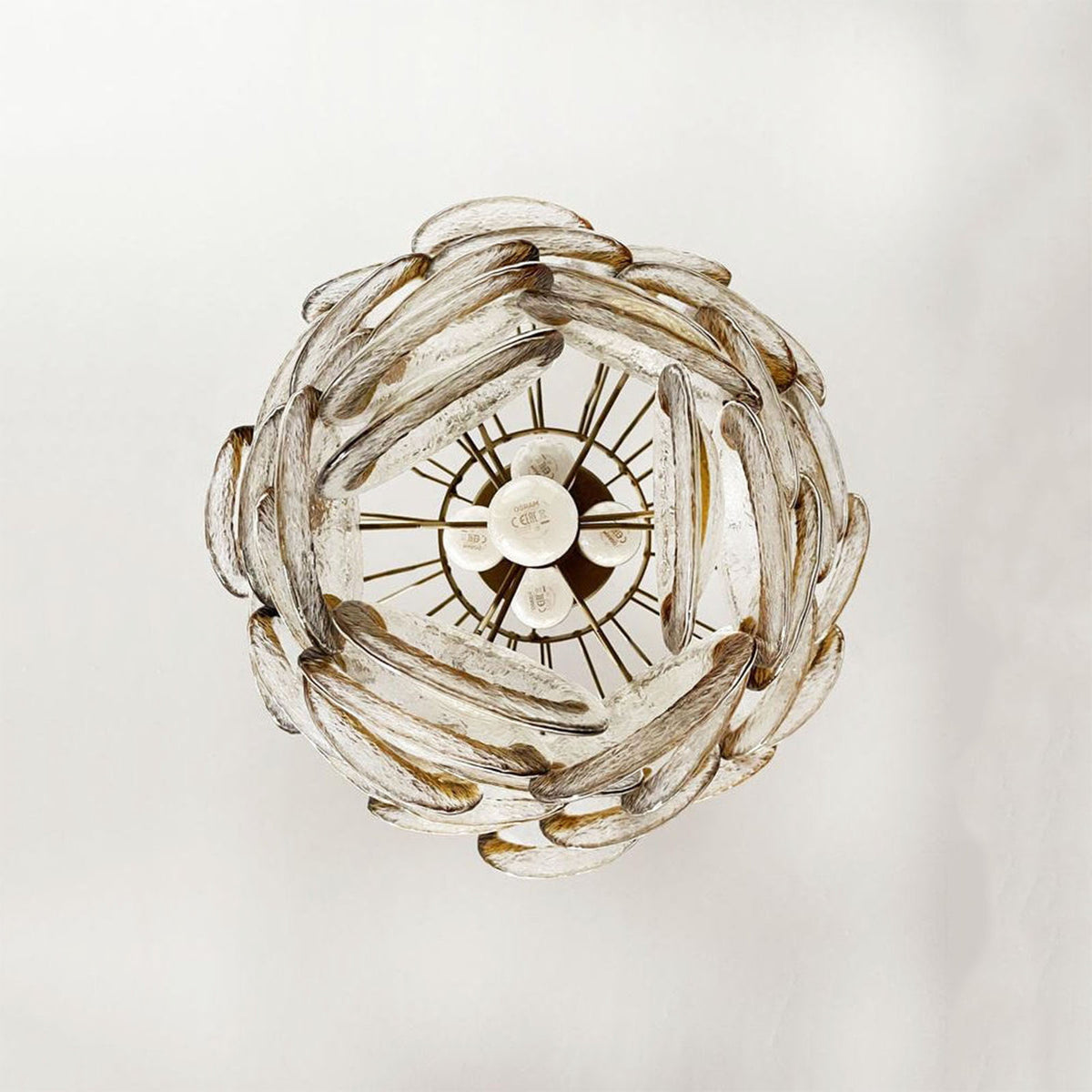 Close-up of the textured surface and amber accents on the glass discs of the Mazzega-style chandelier.