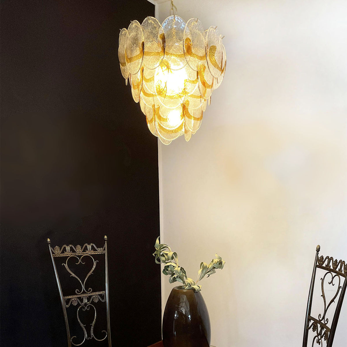 Mazzega-style glass chandelier hanging against a plain white wall, with polished nickel hardware.
