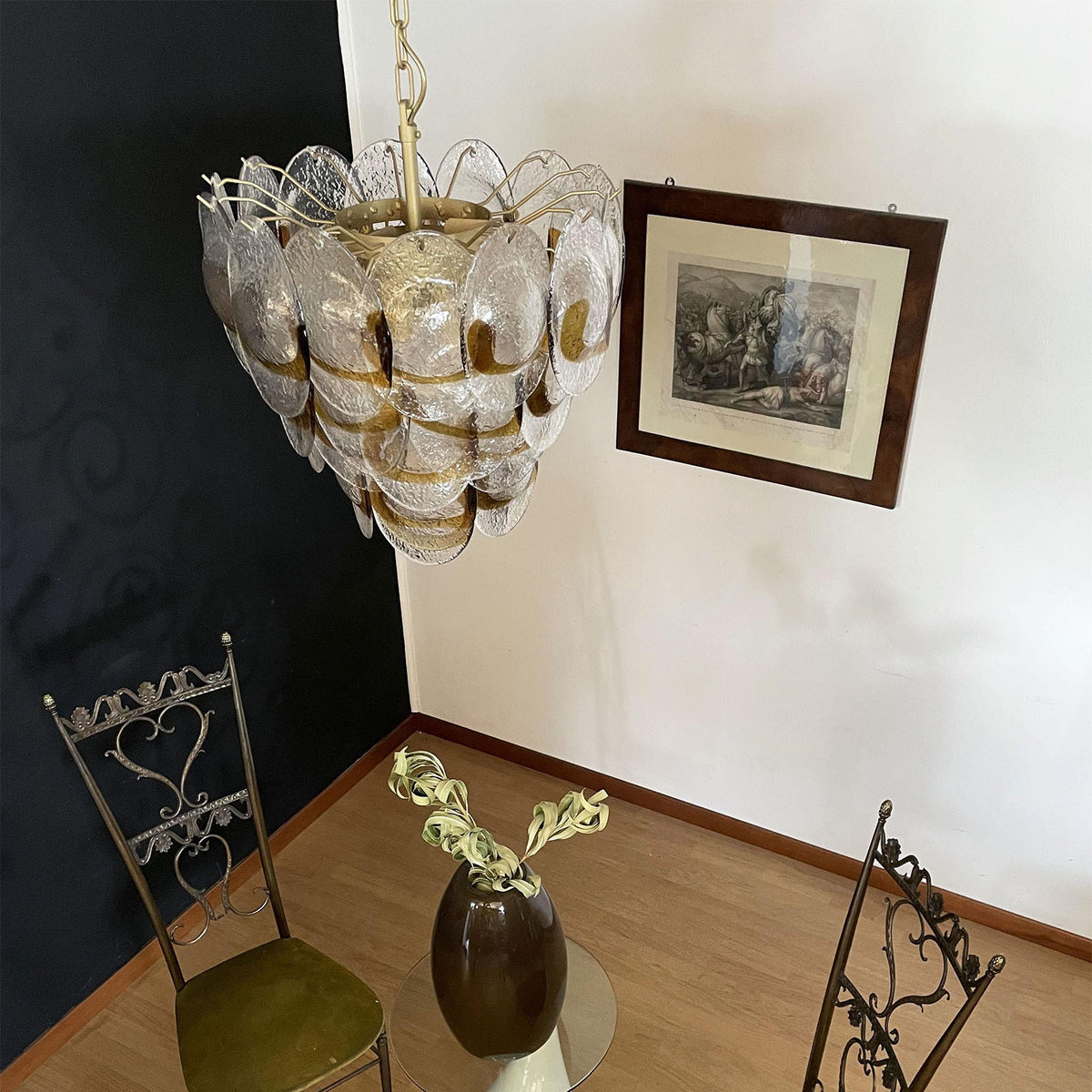 Side view of the Mazzega-style glass chandelier hanging in a room with classic furniture.