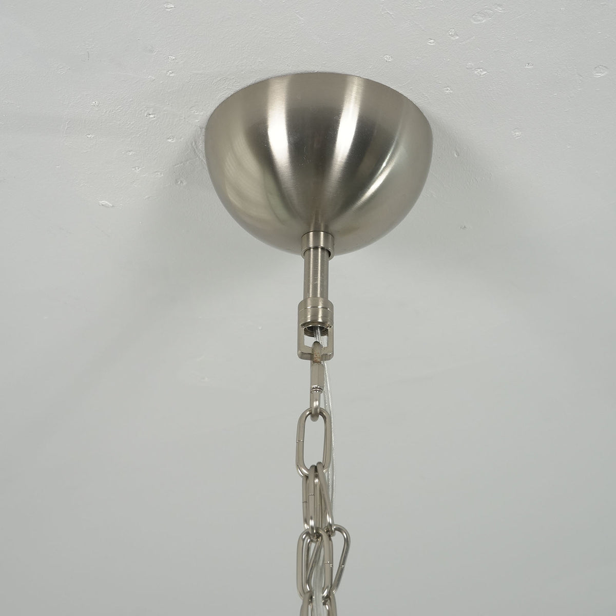 Close-up of the metal hooks that attach the glass discs to the frame on the Mazzega-style chandelier.