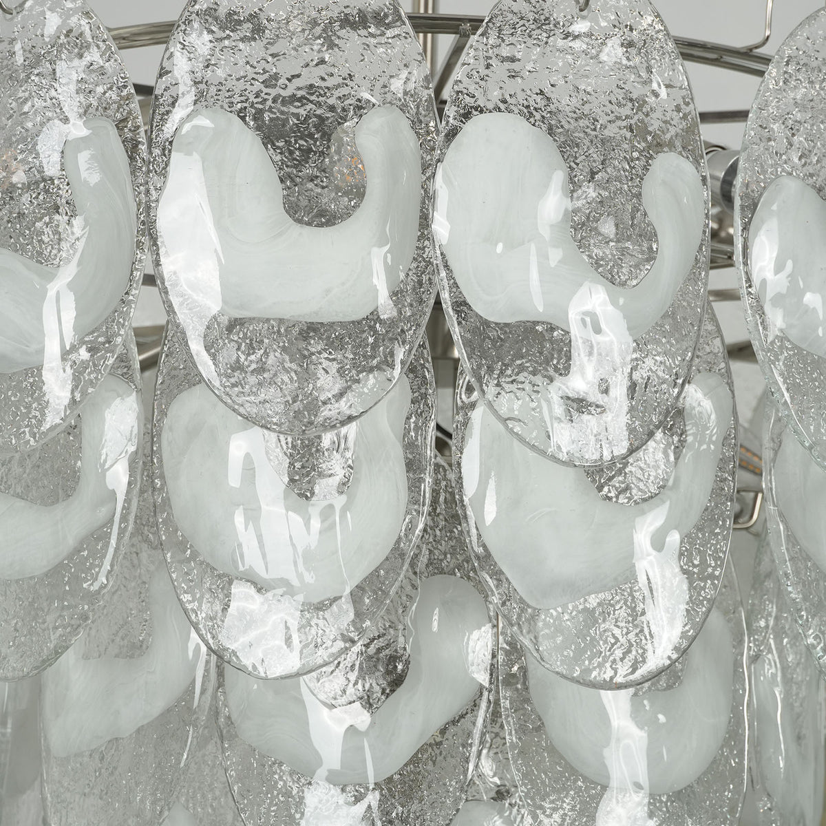 Close-up of the textured glass tiers on the lit Mazzega-style chandelier, showing the white opaque accents.
