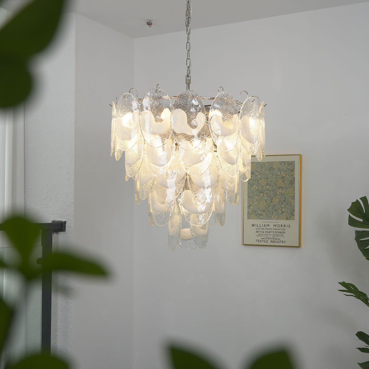 Side view of a lit Mazzega-style white glass chandelier, showing its cascading glass tiers.