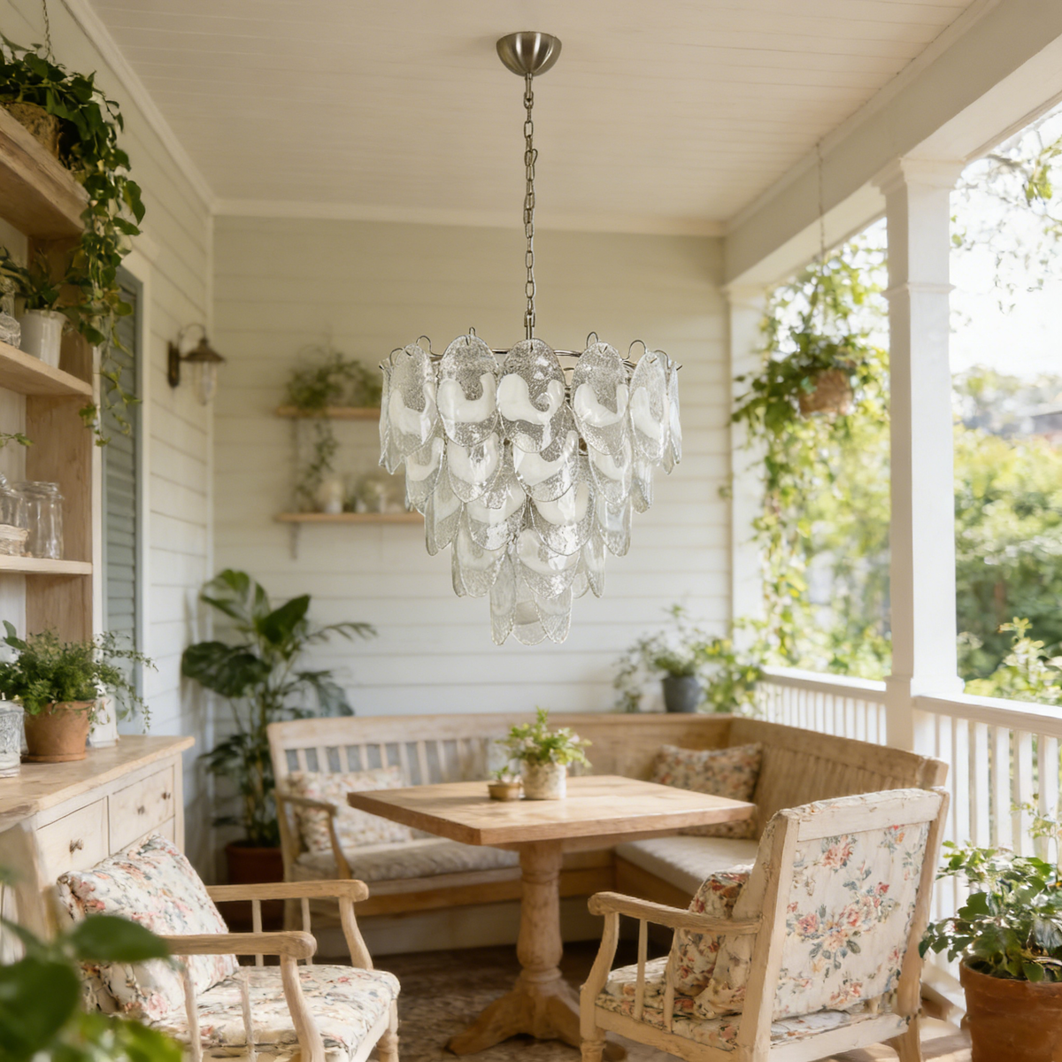 Mazzega-style white glass chandelier hanging in a bright sunroom with floral-patterned furniture and plants.