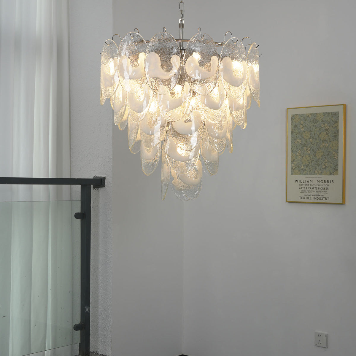 Mazzega-style white glass chandelier hanging alone against a light wall with framed artwork.
