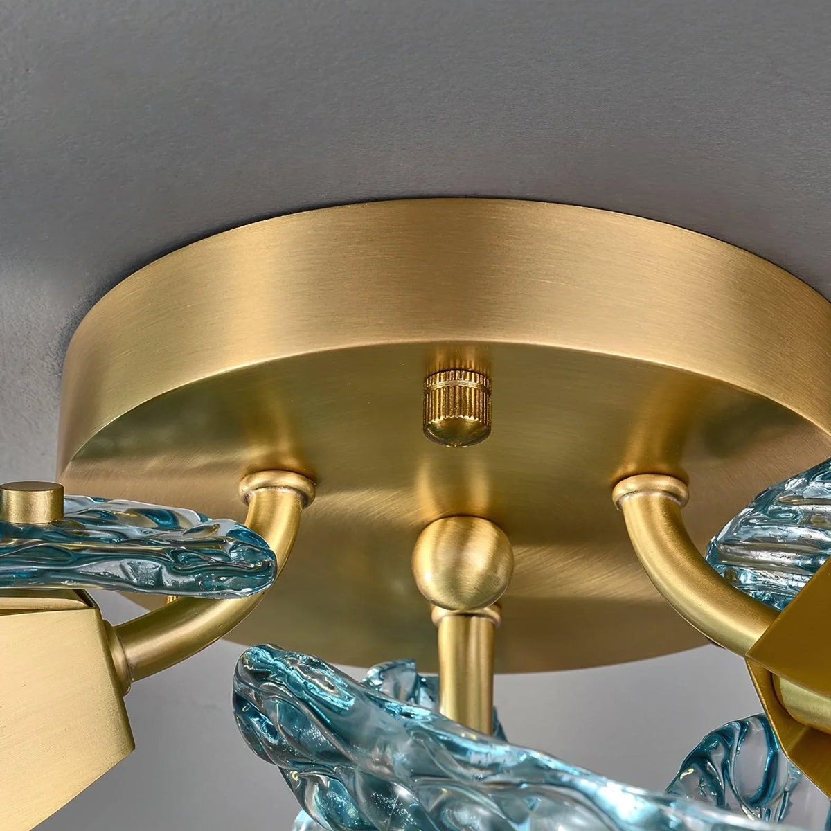 Close-up of the brass ceiling mount and internal frame on the petal blue glass ceiling light.