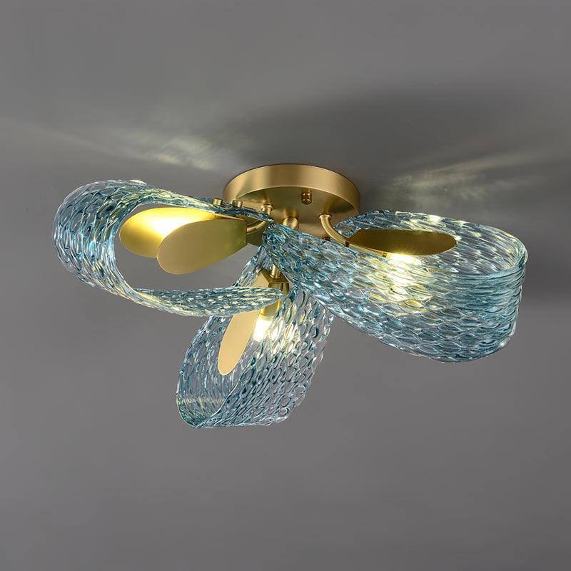 Low-angle view of the lit petal blue glass ceiling light, highlighting the flower-like silhouette.