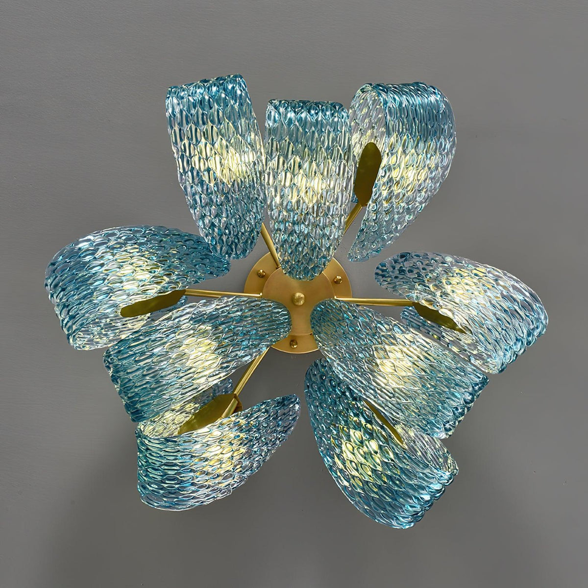 Lit petal blue glass ceiling light, viewed from above, showing the glowing flower-like glass petals.
