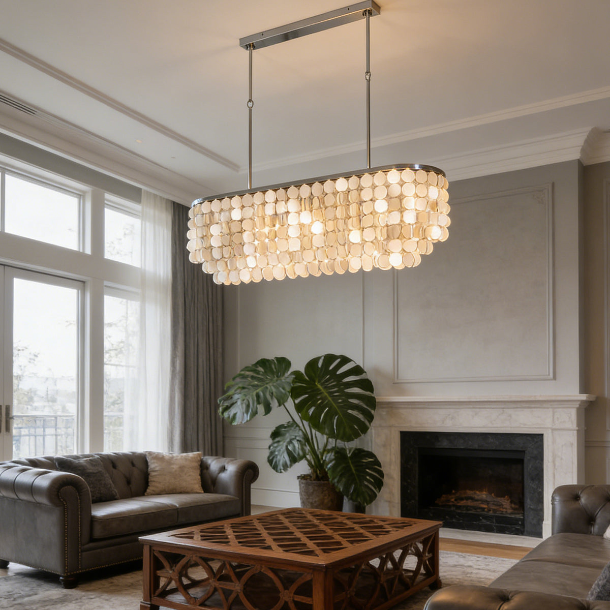 Rectangular capiz shell chandelier in a cozy living room with a fireplace and large potted plants.