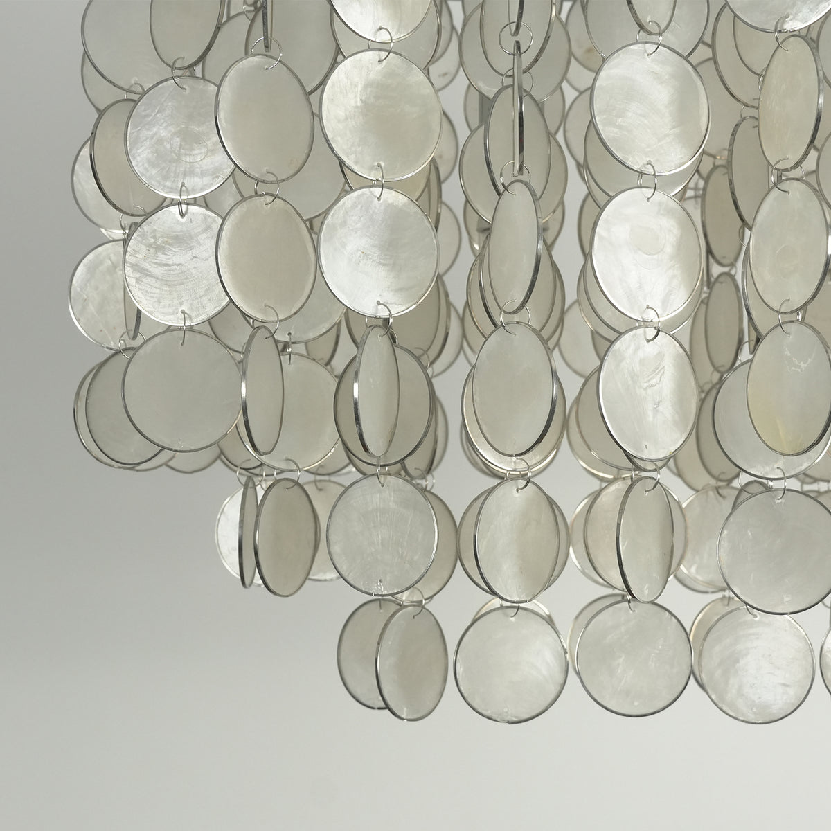 Close-up of the layered arrangement of natural capiz shell discs on the rectangular chandelier.