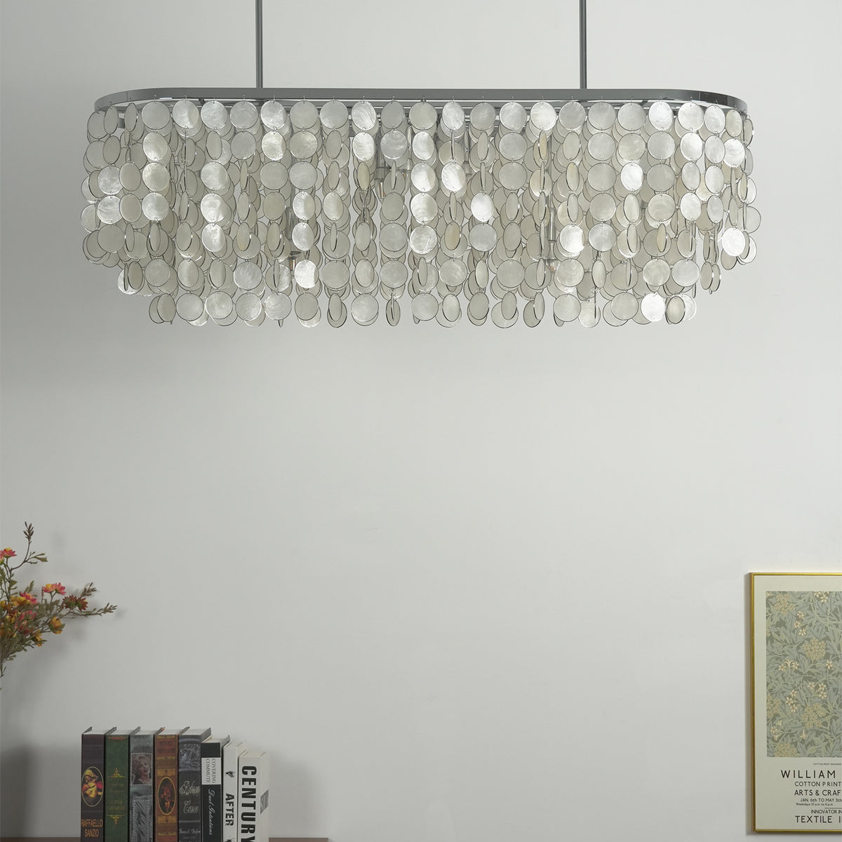Side view of the rectangular capiz shell chandelier hanging in a minimalist room with a light wall.