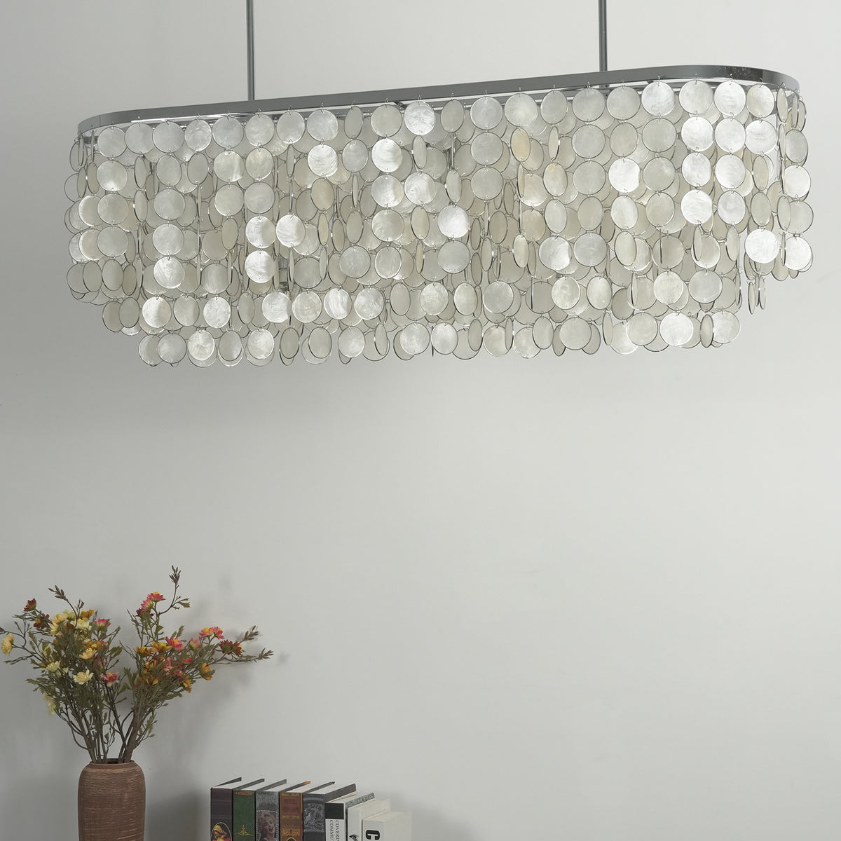 Rectangular capiz shell chandelier hanging alone against a light background, showing its full length.