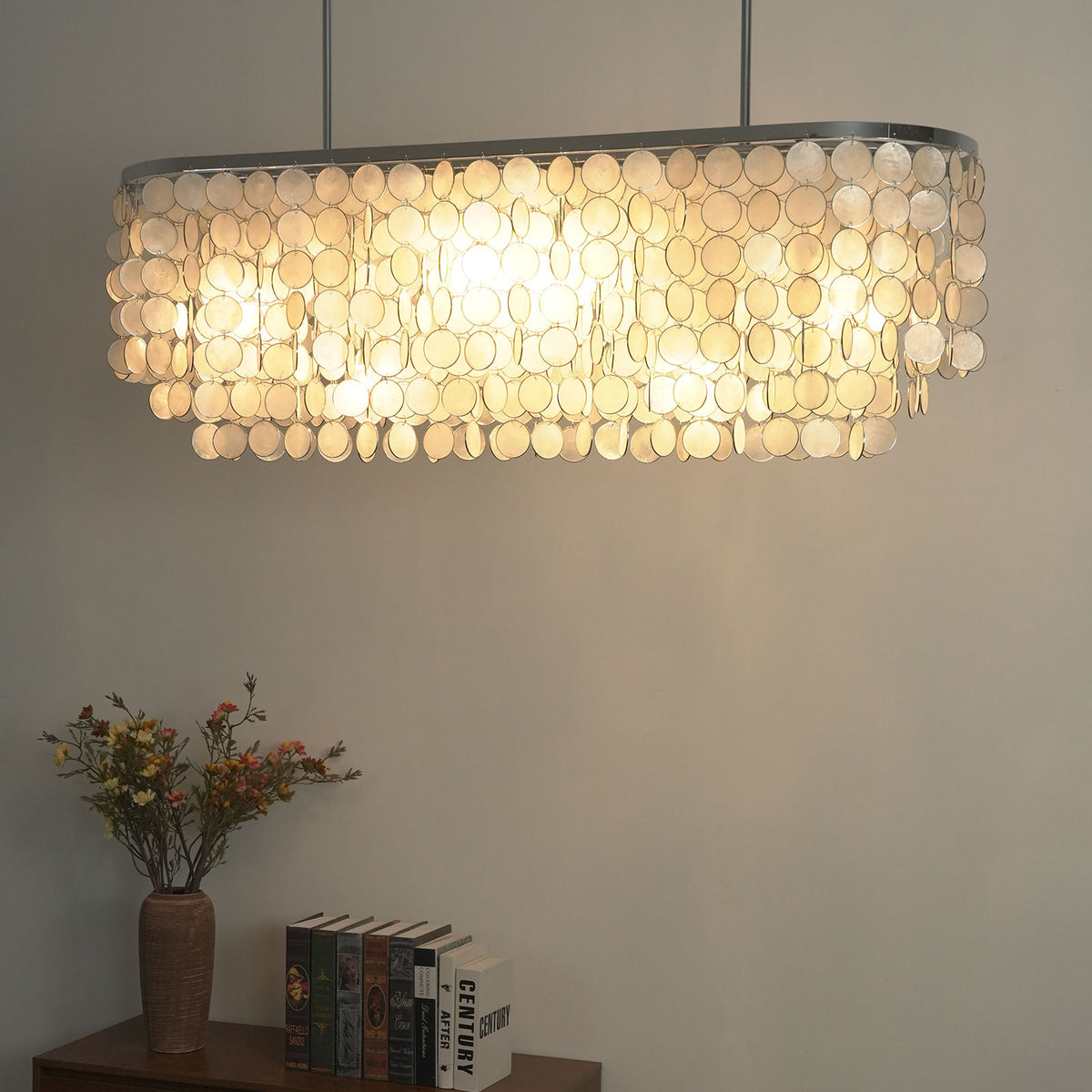 Close-up of a lit rectangular capiz shell chandelier, showing how light filters through natural shell discs.