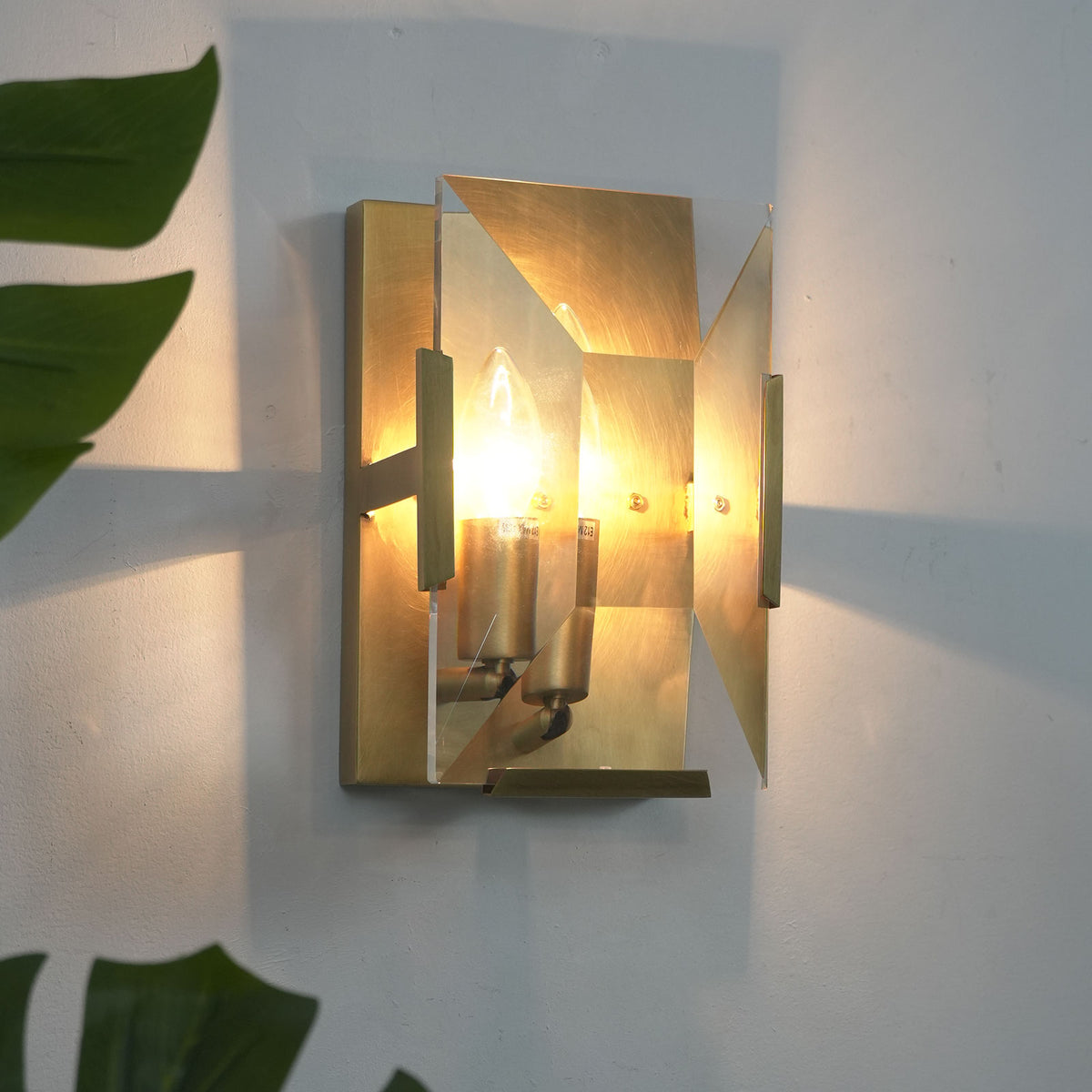 Single-headed crystal wall lamp with brass frame, isolated on a plain white background.