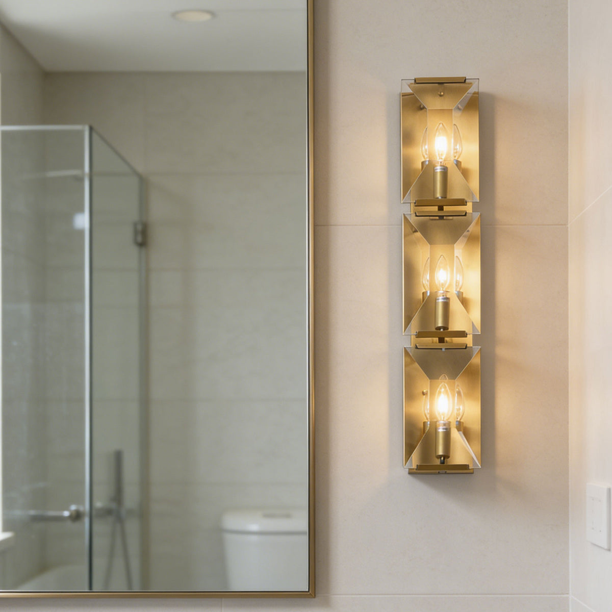 Three-headed crystal wall lamp mounted beside a shower enclosure in a modern bathroom.