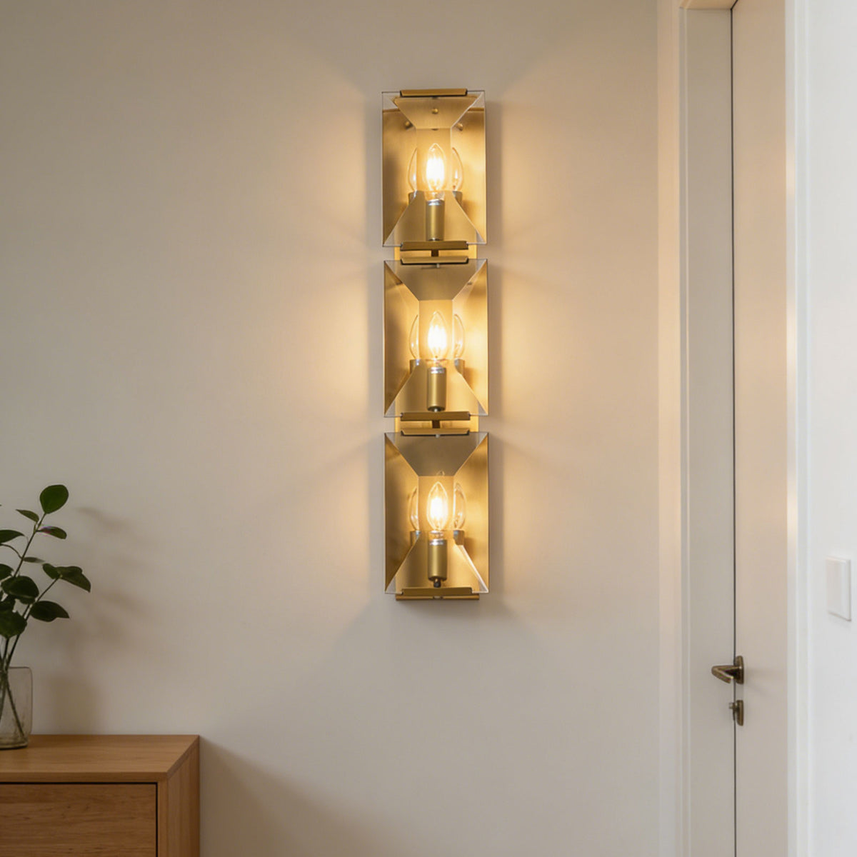 Close-up of the black frame three-headed crystal wall lamp mounted on a light wall.