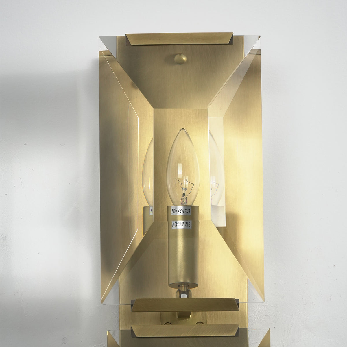 Close-up of the faceted crystal and brass frame on the three-headed wall lamp.