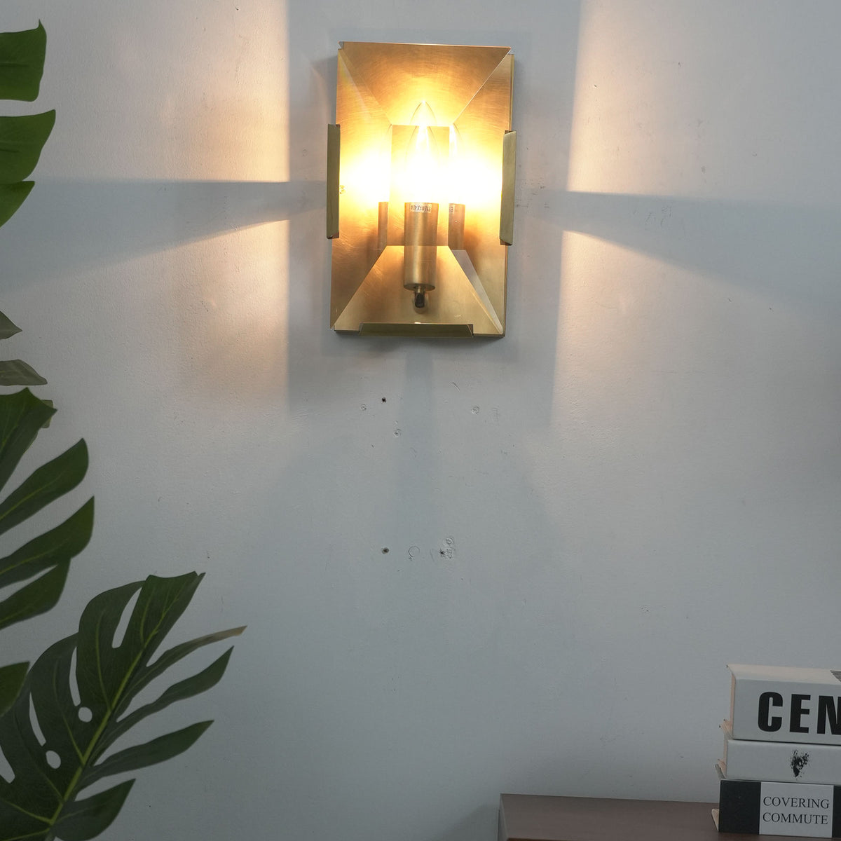Three-headed crystal wall lamp mounted on a wall in a hallway with wooden doors.