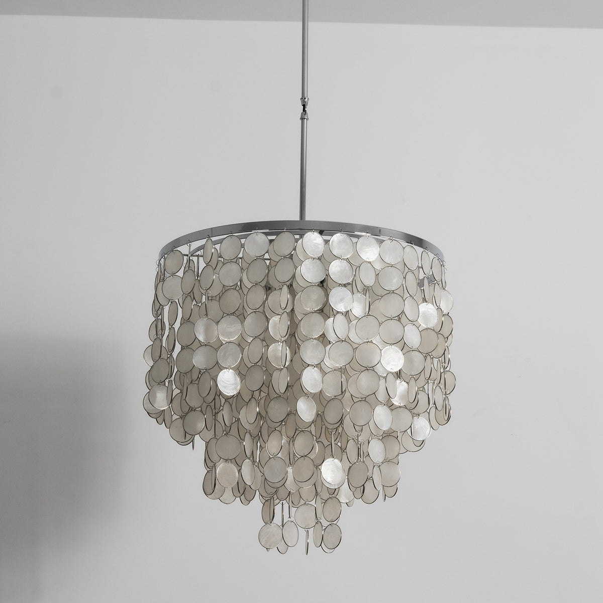 Front view of the tiered capiz shell chandelier against a plain white background, showing its symmetrical design.