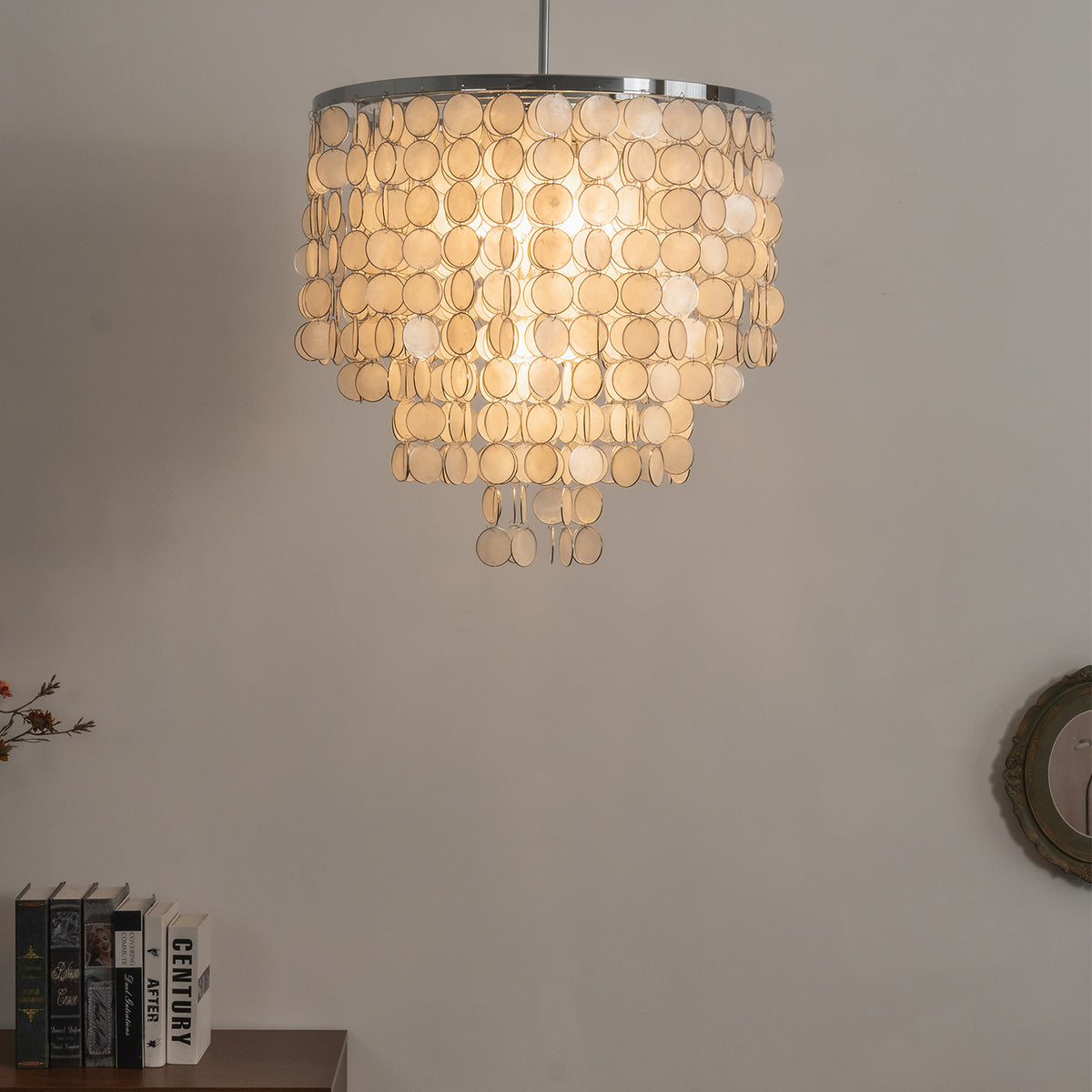 Front view of a lit tiered capiz shell chandelier, highlighting its symmetrical cascading design.