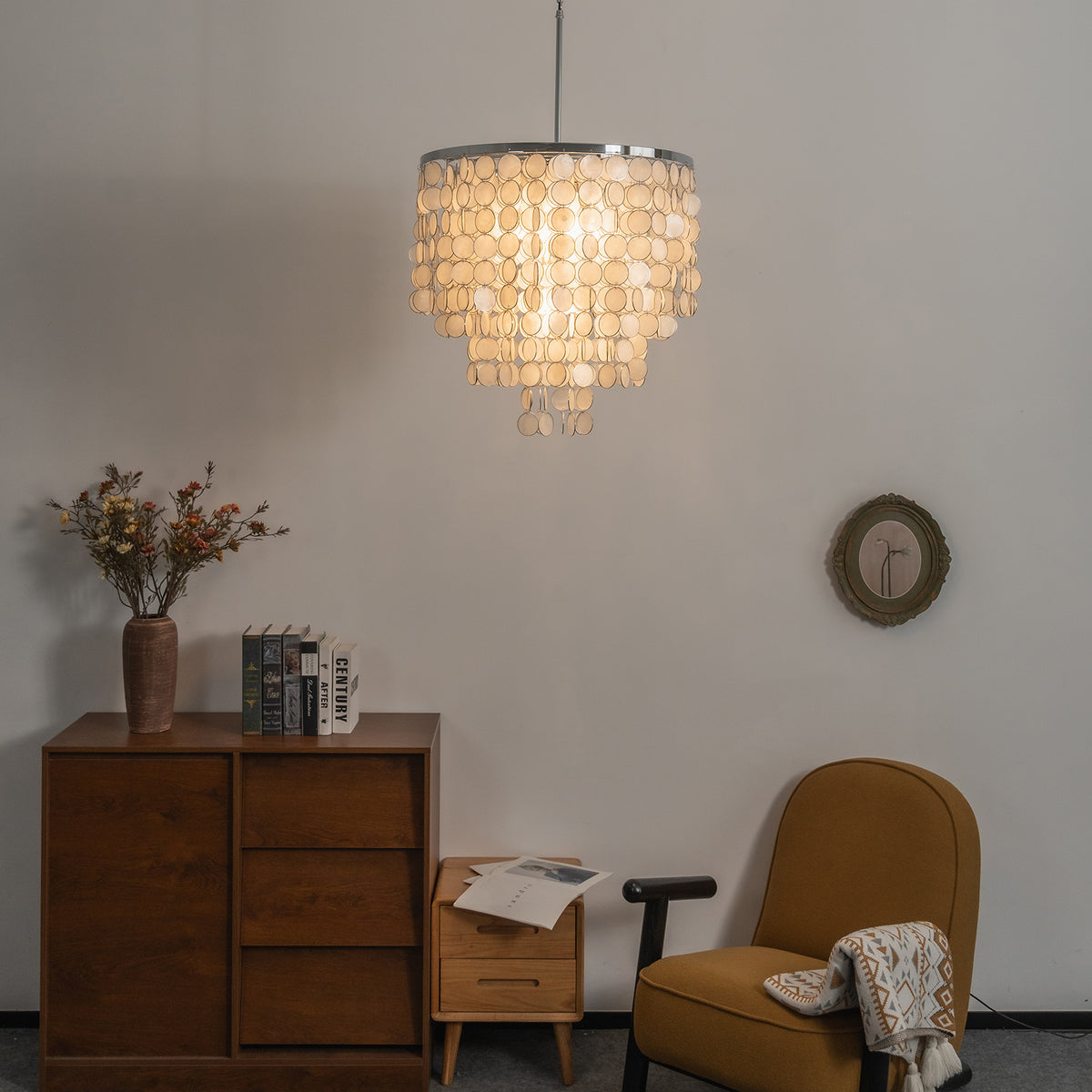 Tiered capiz shell chandelier hanging in a minimalist home office with a wooden desk and chair.